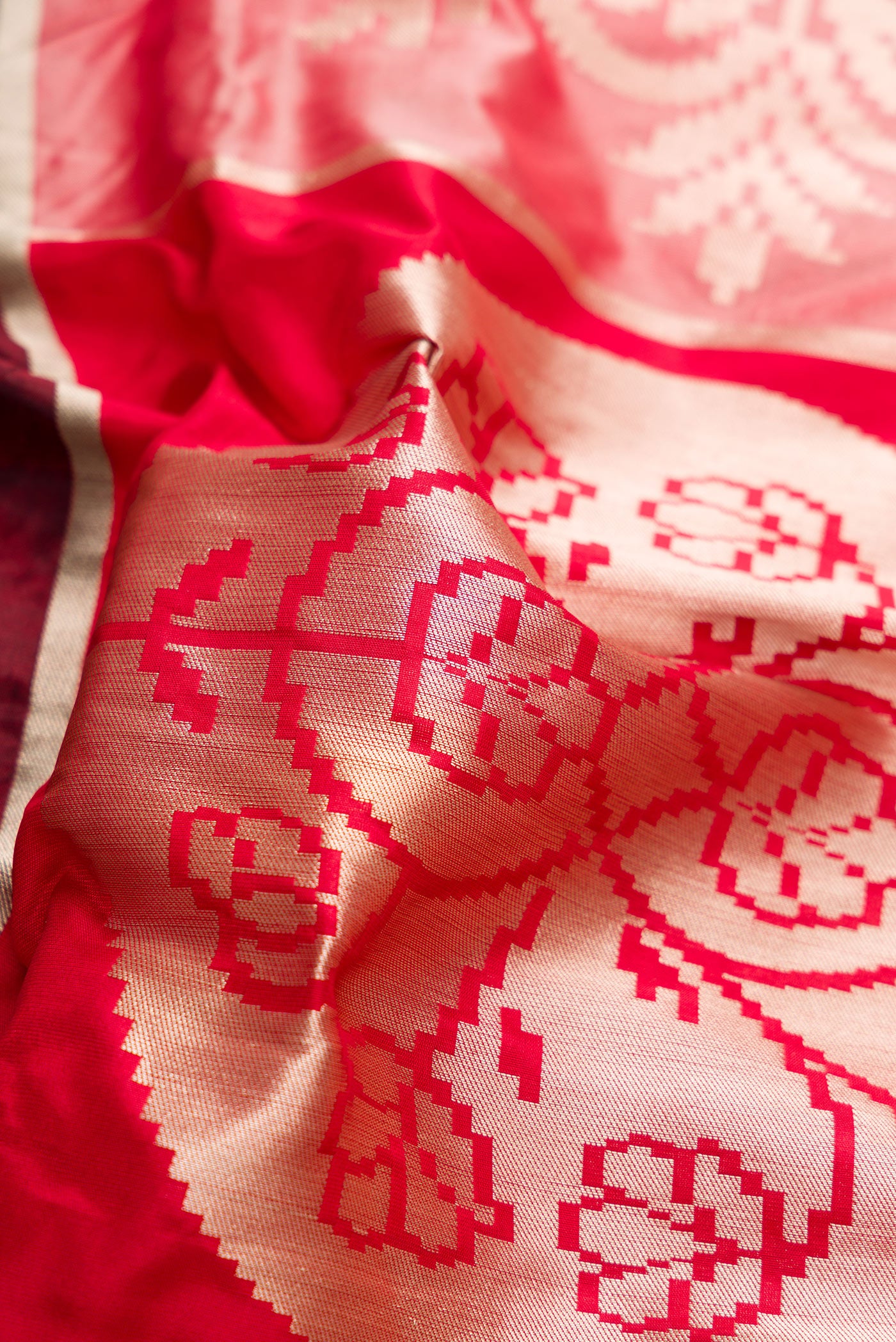 Close up of Red, Maroon, Black and Off White Color Banarasi Silk Saree with Zari Brocade on the body and Zari Border.  displaying folds