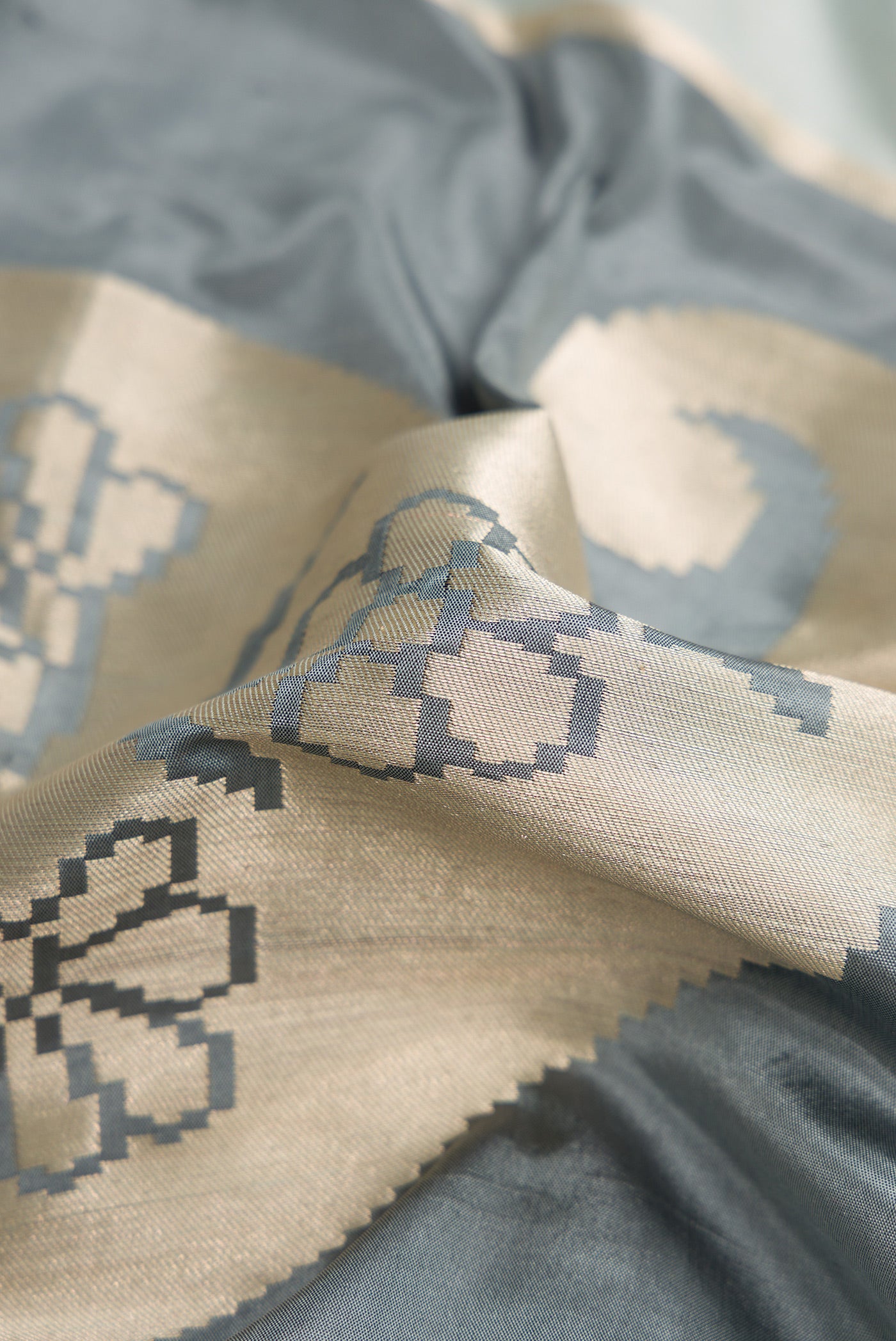 Close up of Black, Grey and Off White Color Banarasi Silk Saree with Zari Brocade on the body and Zari Border.  displaying folds