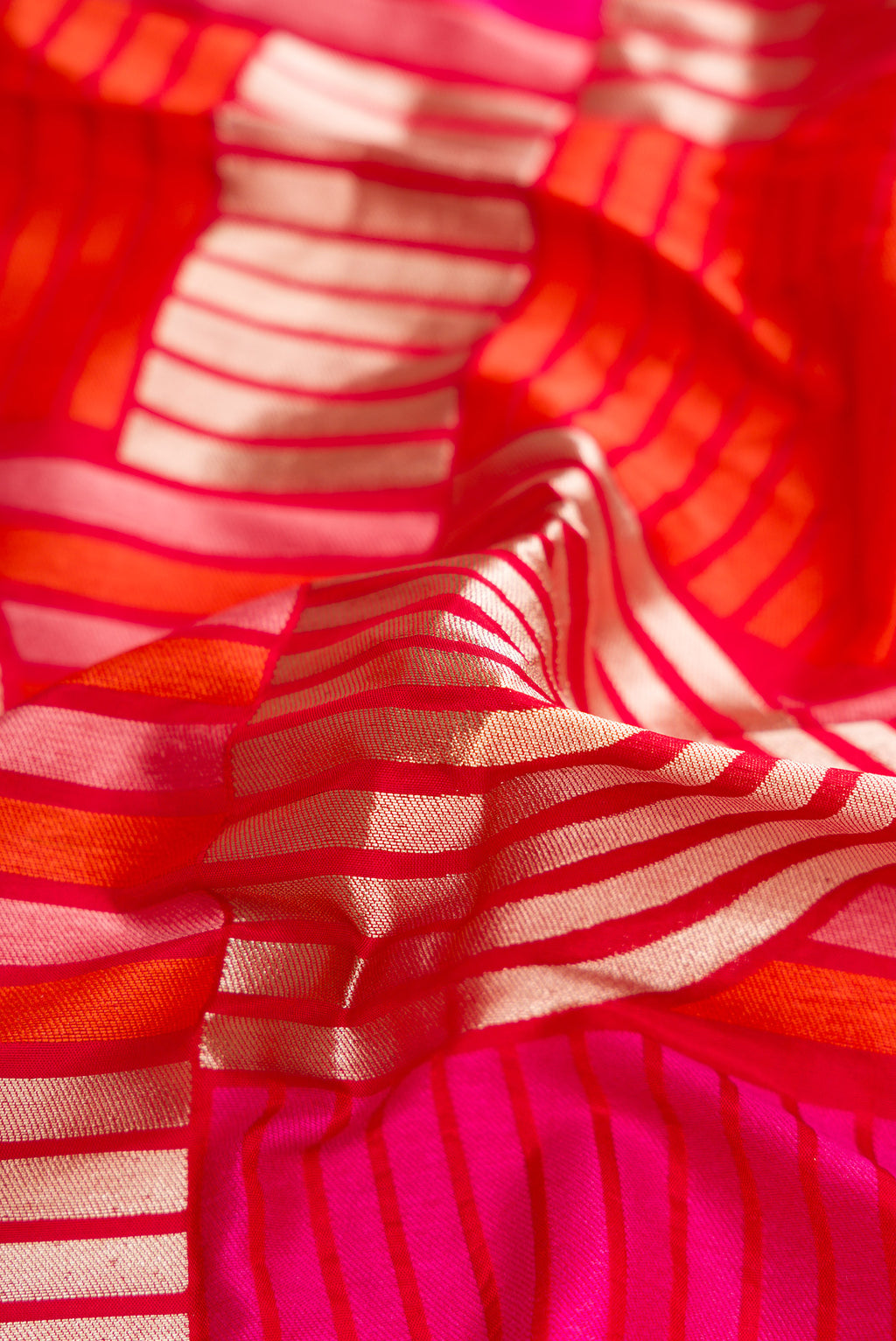 Close up of Red Dual Tone Banarasi Silk Saree with Zari Brocade on the body and Zari Border.  displaying folds