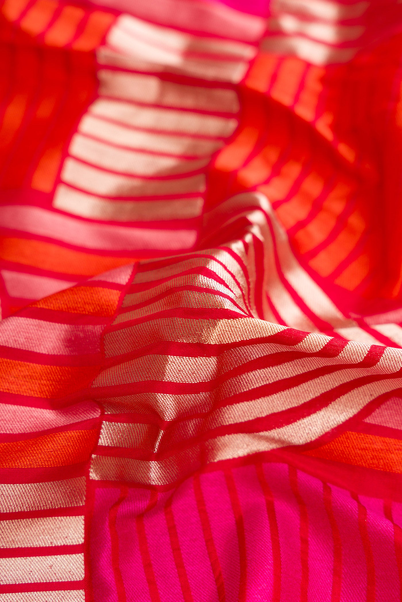 Close up of Red Dual Tone Banarasi Silk Saree with Zari Brocade on the body and Zari Border.  displaying folds