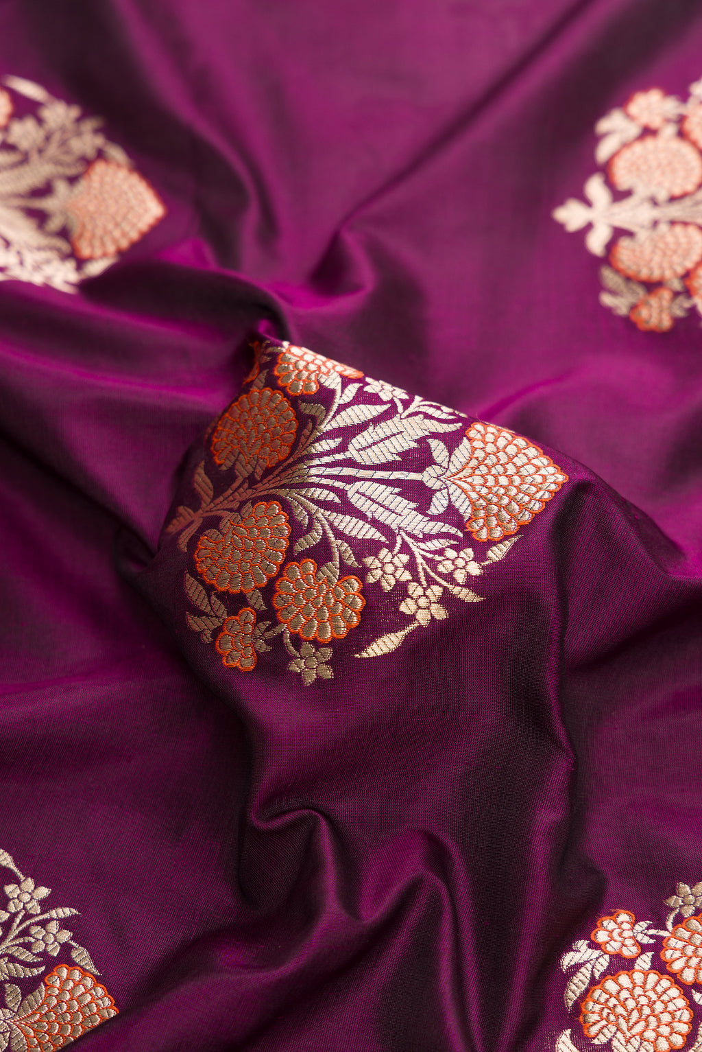 Close up of Burgundy Dual Tone Banarasi Silk Saree with Zari Butta on the body and Fancy Border.  displaying folds