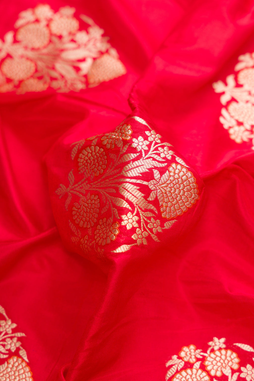 Close up of Red Dual Tone Banarasi Silk Saree with Zari And Thread Butta on the body and Zari Border.  displaying folds