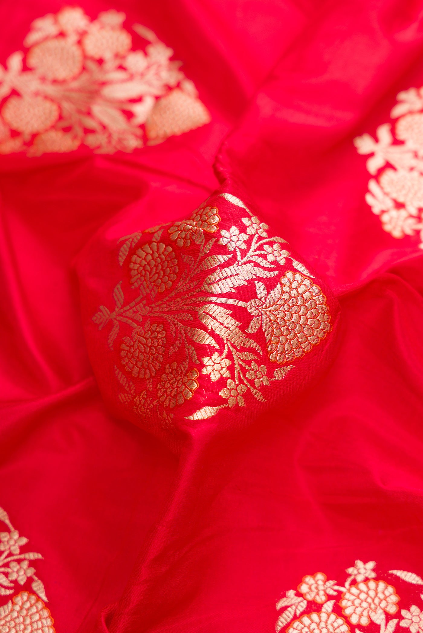Close up of Red Dual Tone Banarasi Silk Saree with Zari And Thread Butta on the body and Zari Border.  displaying folds