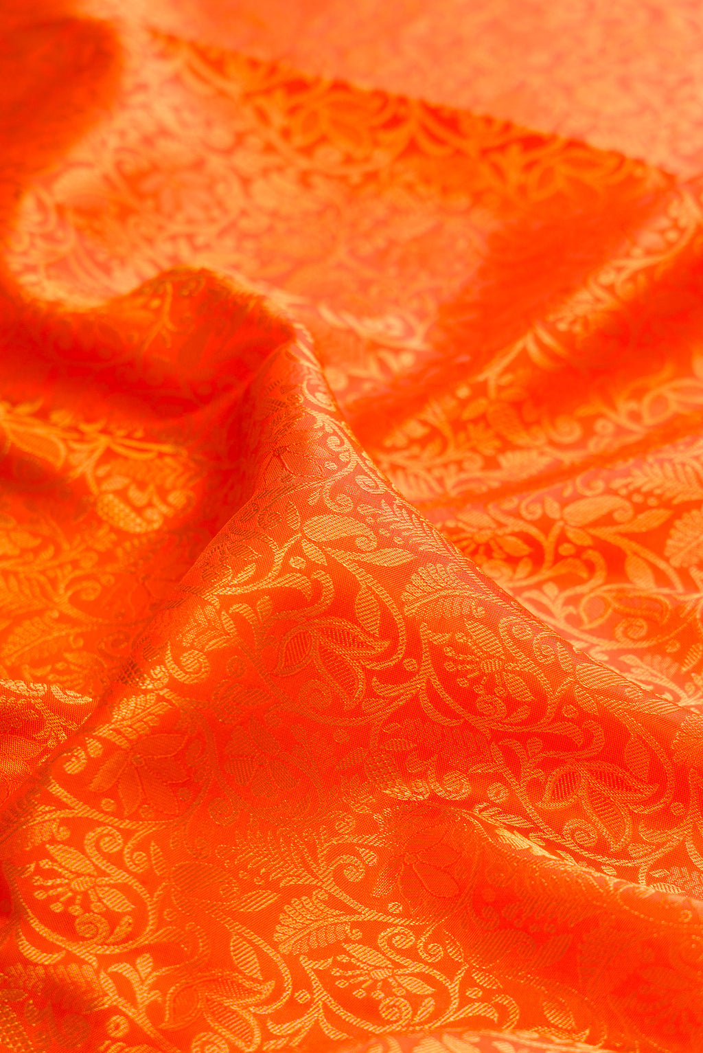 Close up of Pure Silk Orange Kanjivaram Saree with Zari Brocade on the body and Zari Border.  displaying folds