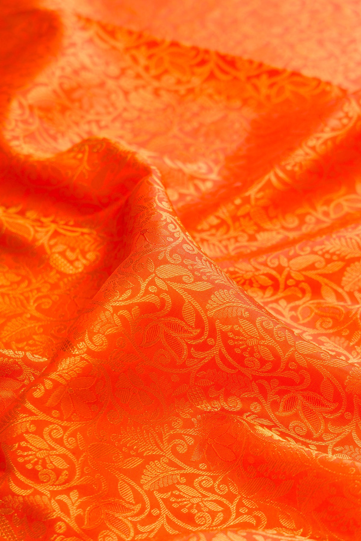 Close up of Pure Silk Orange Kanjivaram Saree with Zari Brocade on the body and Zari Border.  displaying folds