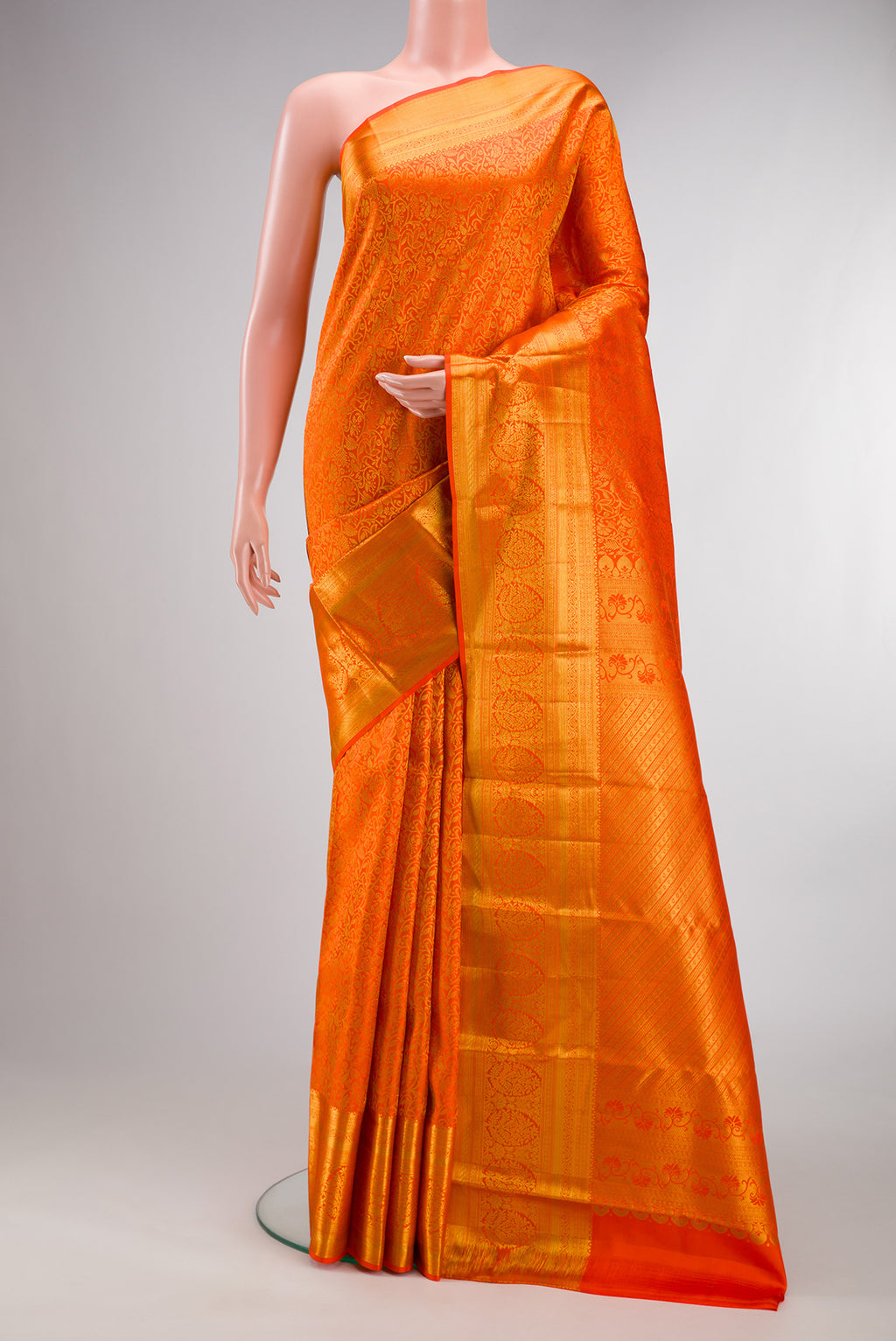 Pure Silk Orange Kanjivaram Saree with Zari Brocade on the body and Zari Border.  displayed on a mannequin