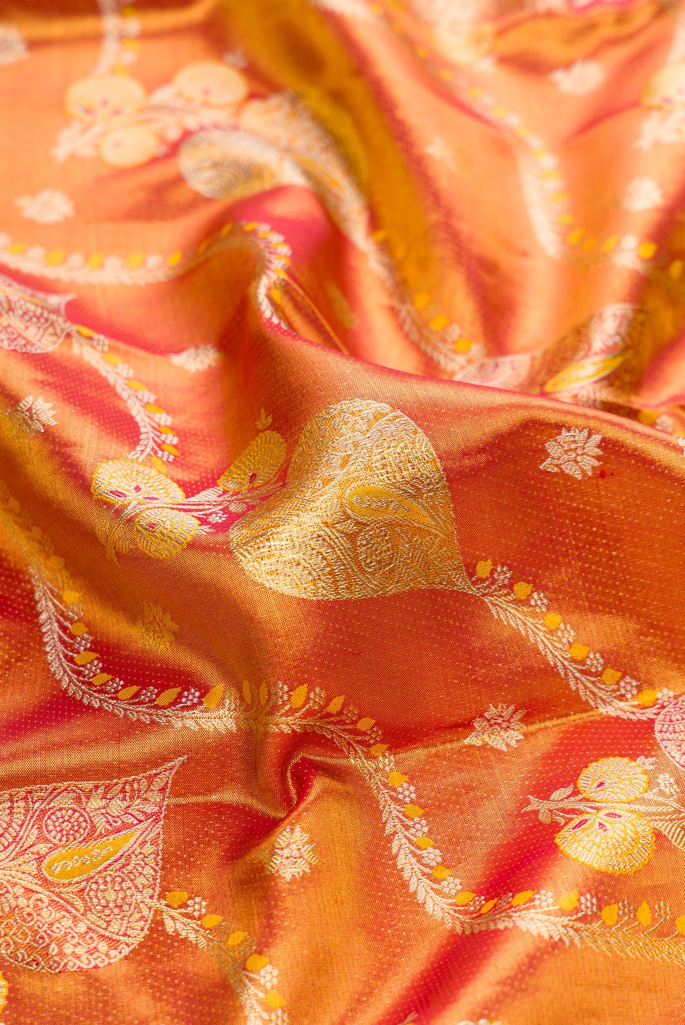 Close up of Red Dual Tone Kanjivaram Tissue Silk Saree with Zari Brocade on the body and Zari Border.  displaying folds