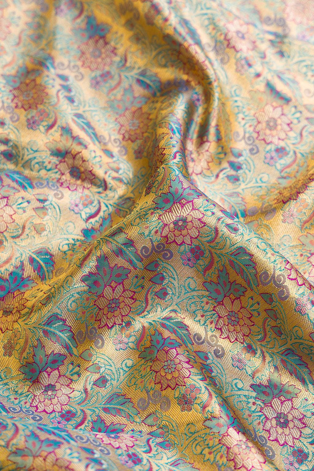 Close up of Gold Dual Tone Kanjivaram Tissue Silk Saree with Zari Brocade on the body and Zari Border.  displaying folds