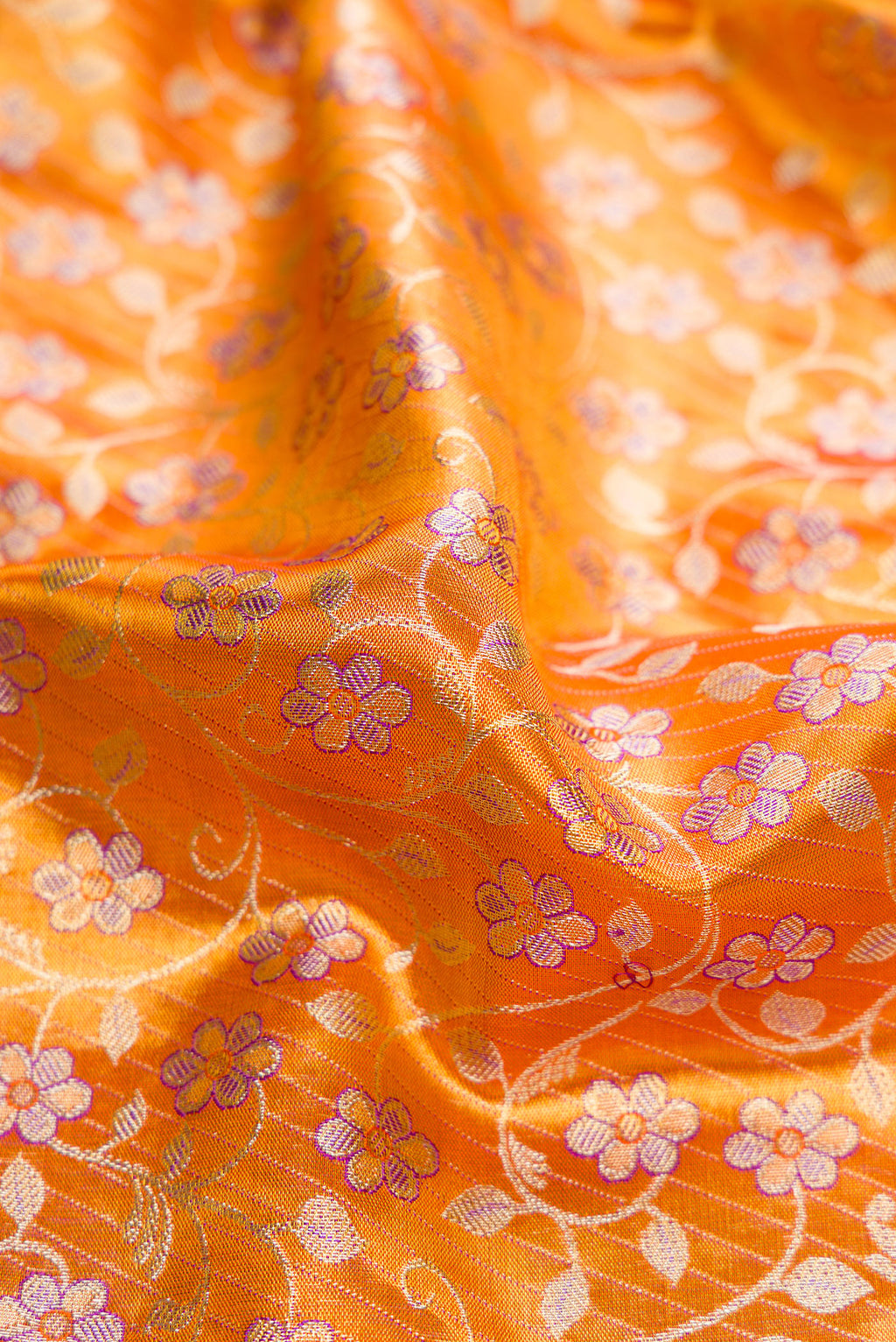 Close up of Golden Peach Dual Tone Kanjivaram Tissue Silk Saree with Zari Brocade on the body and Fancy Border.  displaying folds