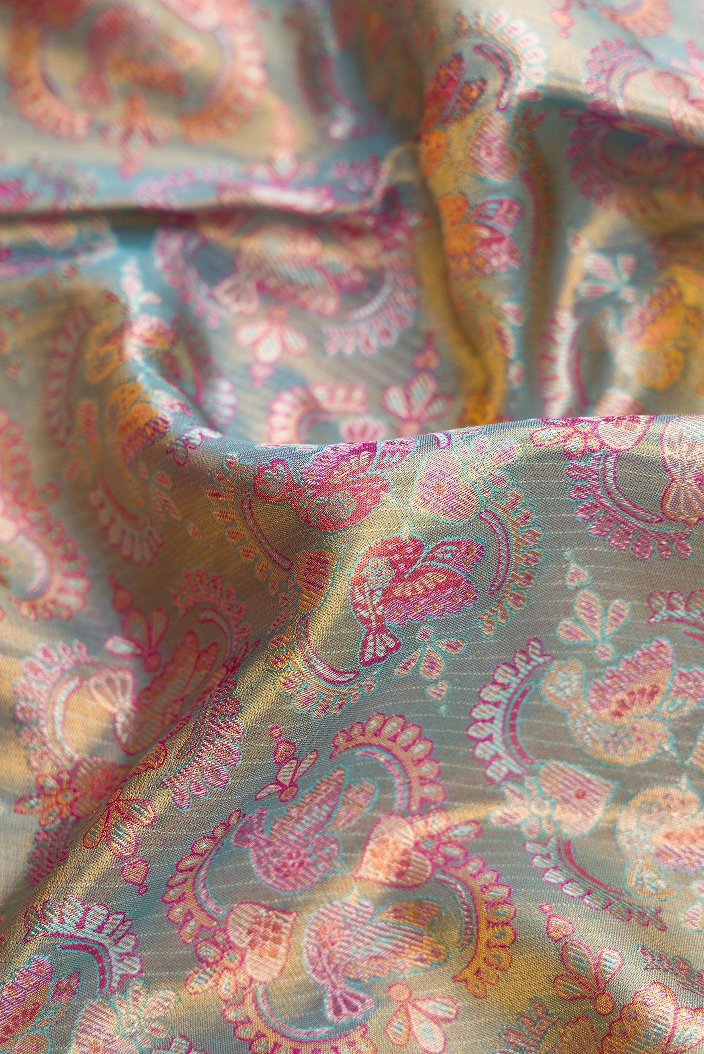 Close up of Sea Green Dual Tone Kanjivaram Tissue Silk Saree with Zari Brocade on the body and Fancy Border.  displaying folds