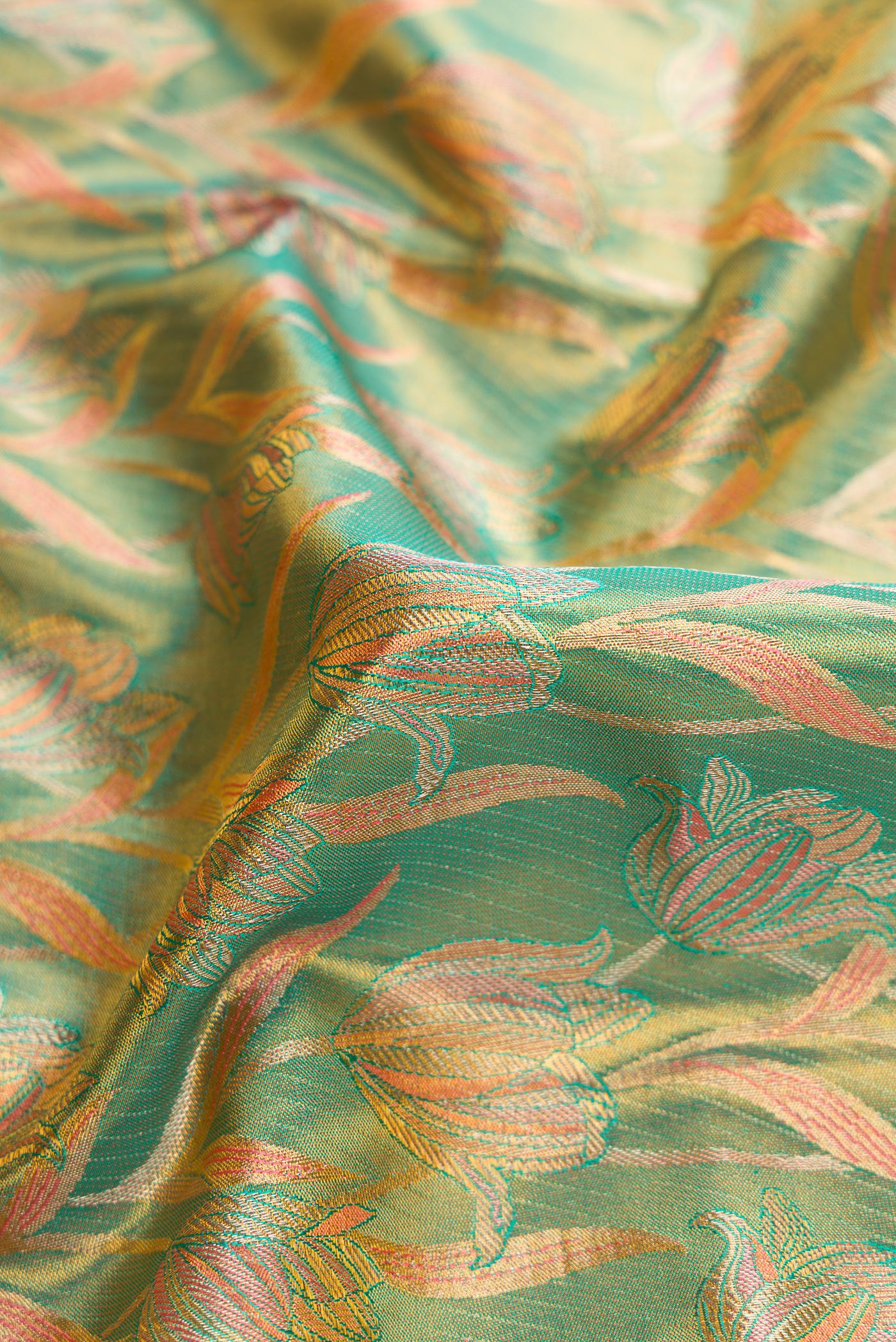 Close up of Green Dual Tone Kanjivaram Tissue Silk Saree with Zari Brocade on the body and Fancy Border.  displaying folds