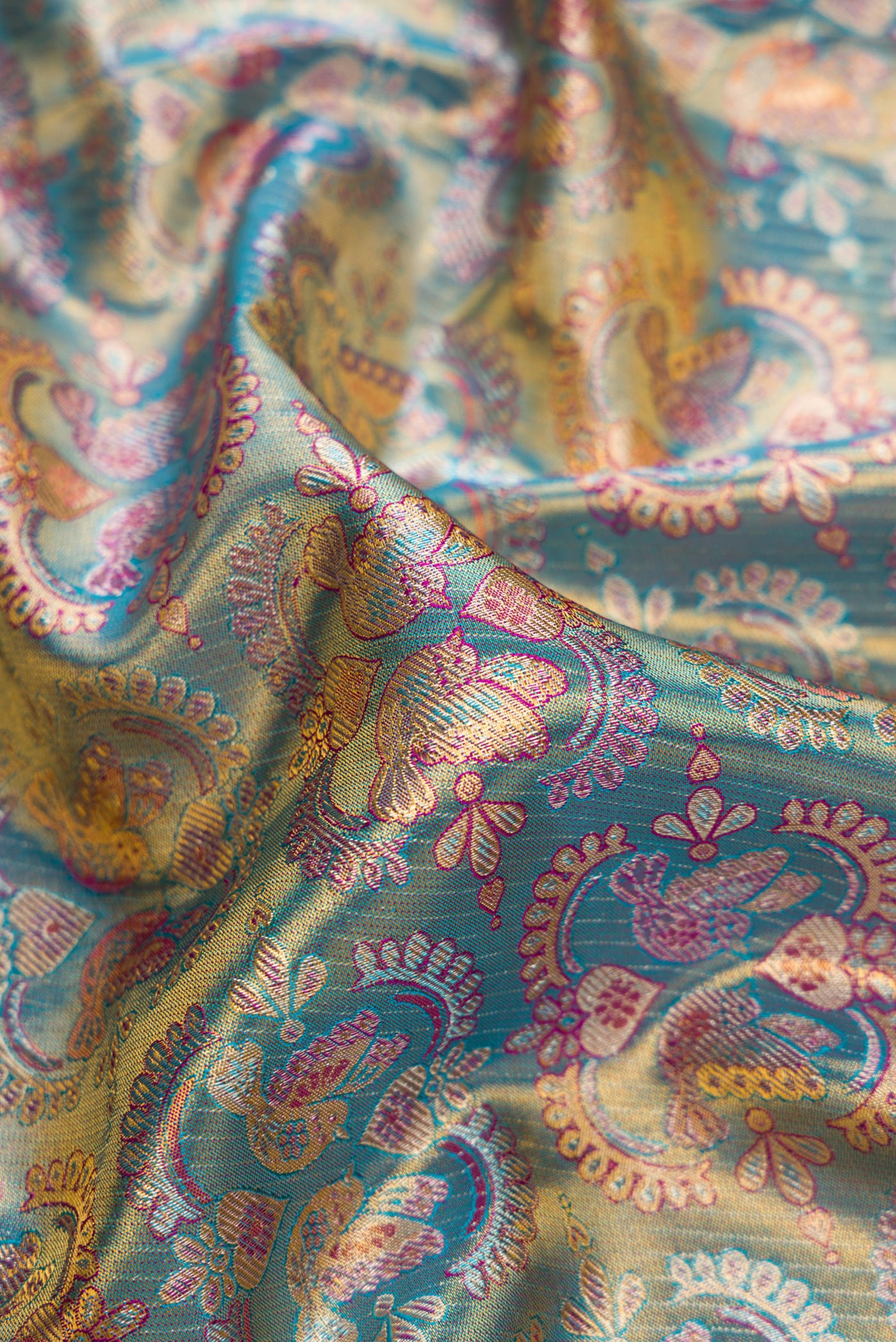 Close up of Light Blue Dual Tone Kanjivaram Tissue Silk Saree with Zari Brocade on the body and Fancy Border.  displaying folds