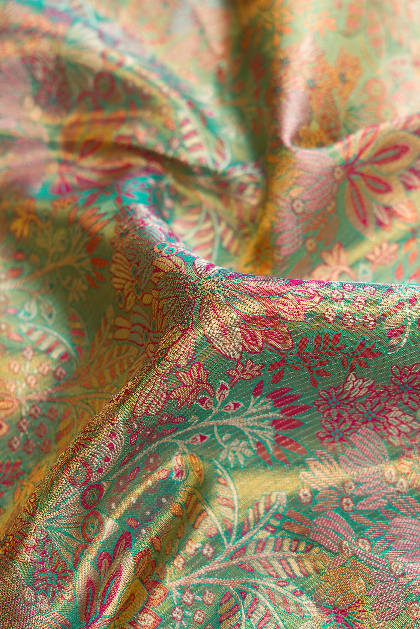 Close up of Sea Green Dual Tone Kanjivaram Tissue Silk Saree with Zari Brocade on the body and Fancy Border.  displaying folds