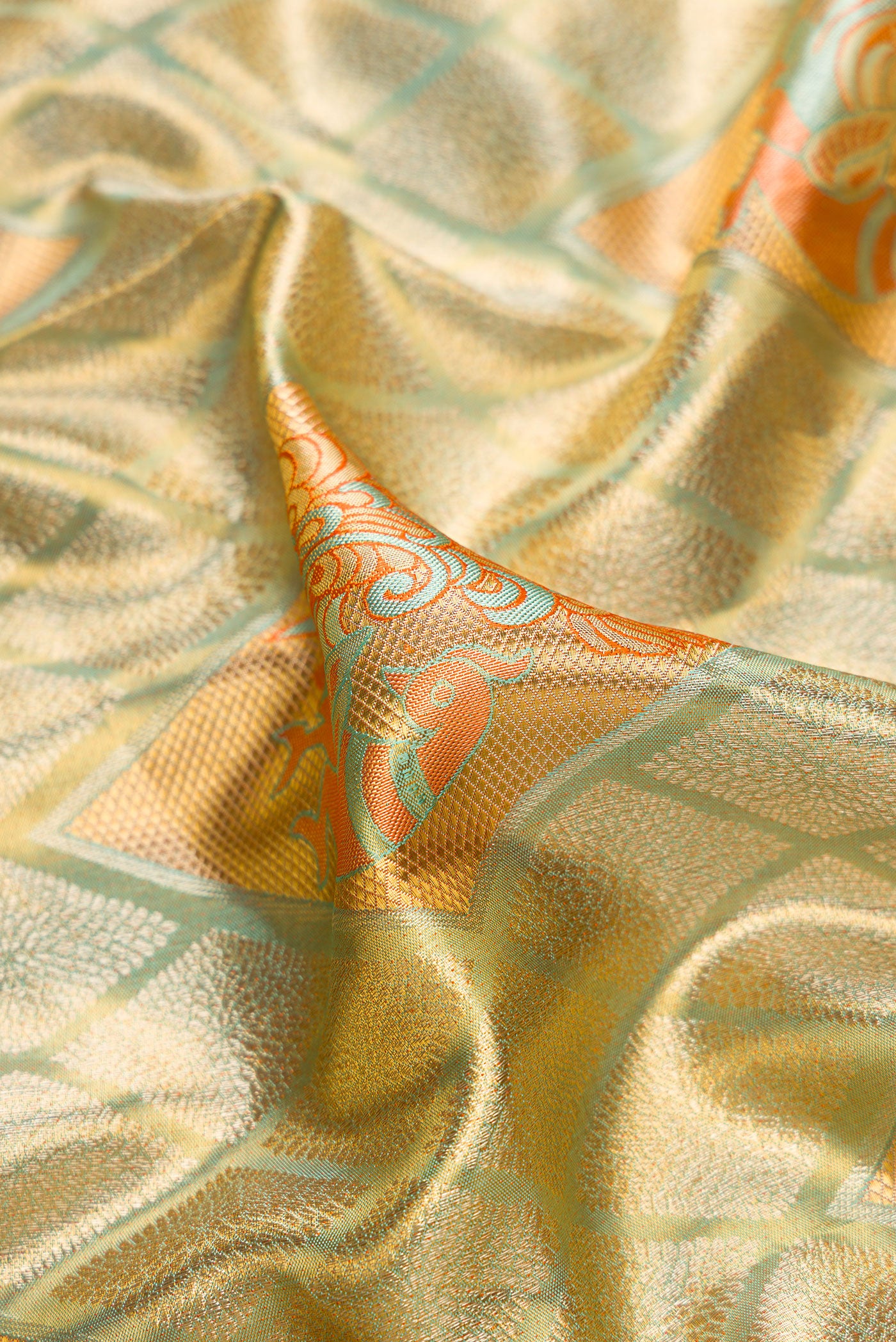 Close up of Light Green Dual Tone Kanjivaram Tissue Silk Saree with Zari Brocade on the body and Zari Border.  displaying folds