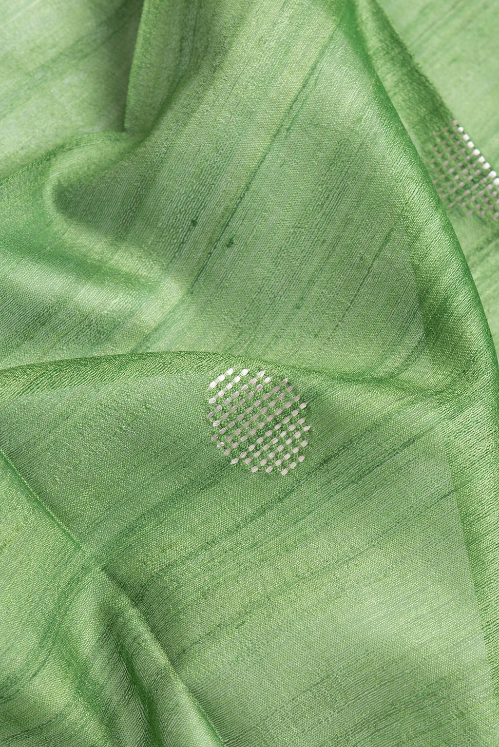 Close up of Parrot Green Dual Tone Tussar Silk Saree with Zari Butta on the body and Zari Border.  displaying folds