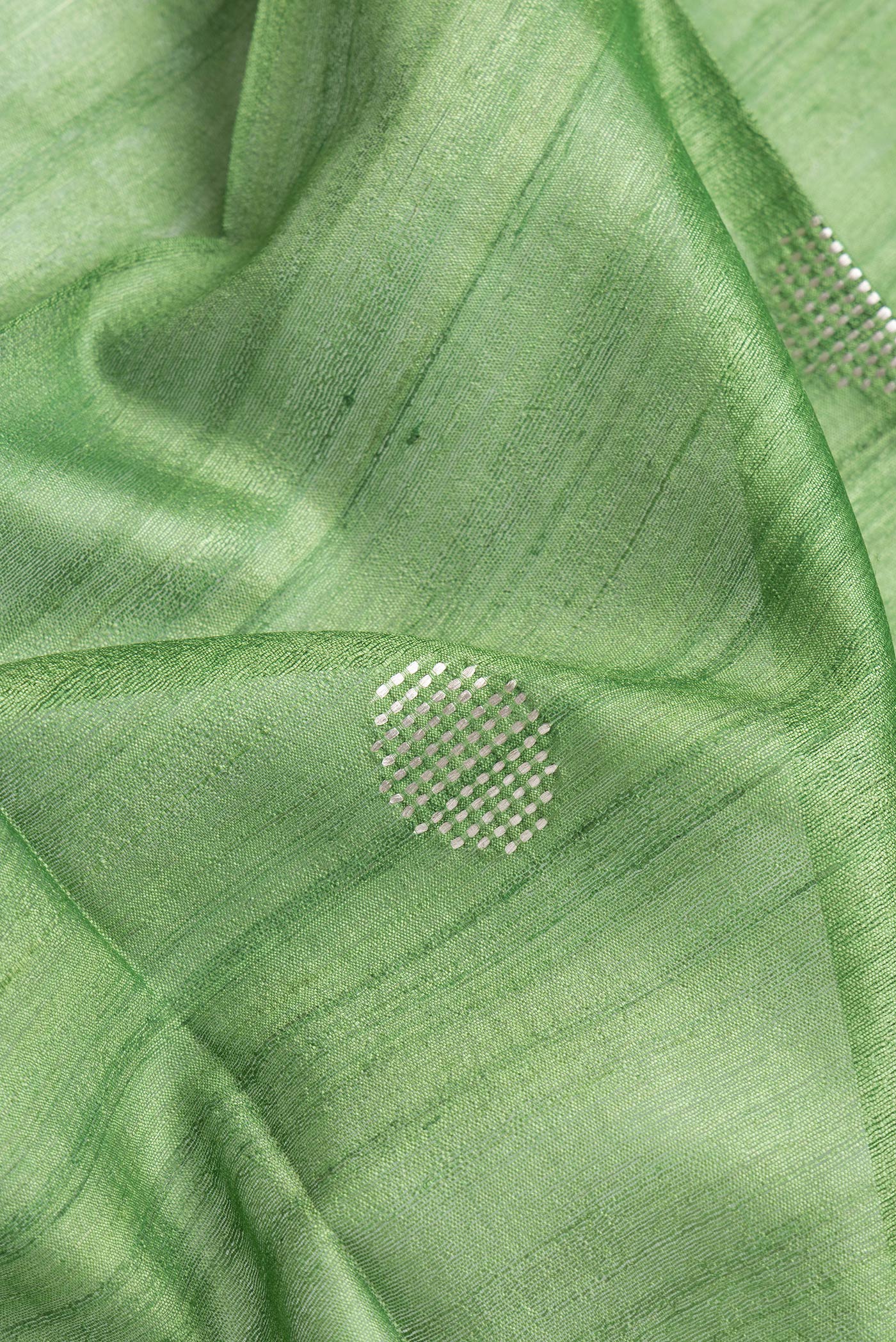 Close up of Parrot Green Dual Tone Tussar Silk Saree with Zari Butta on the body and Zari Border.  displaying folds