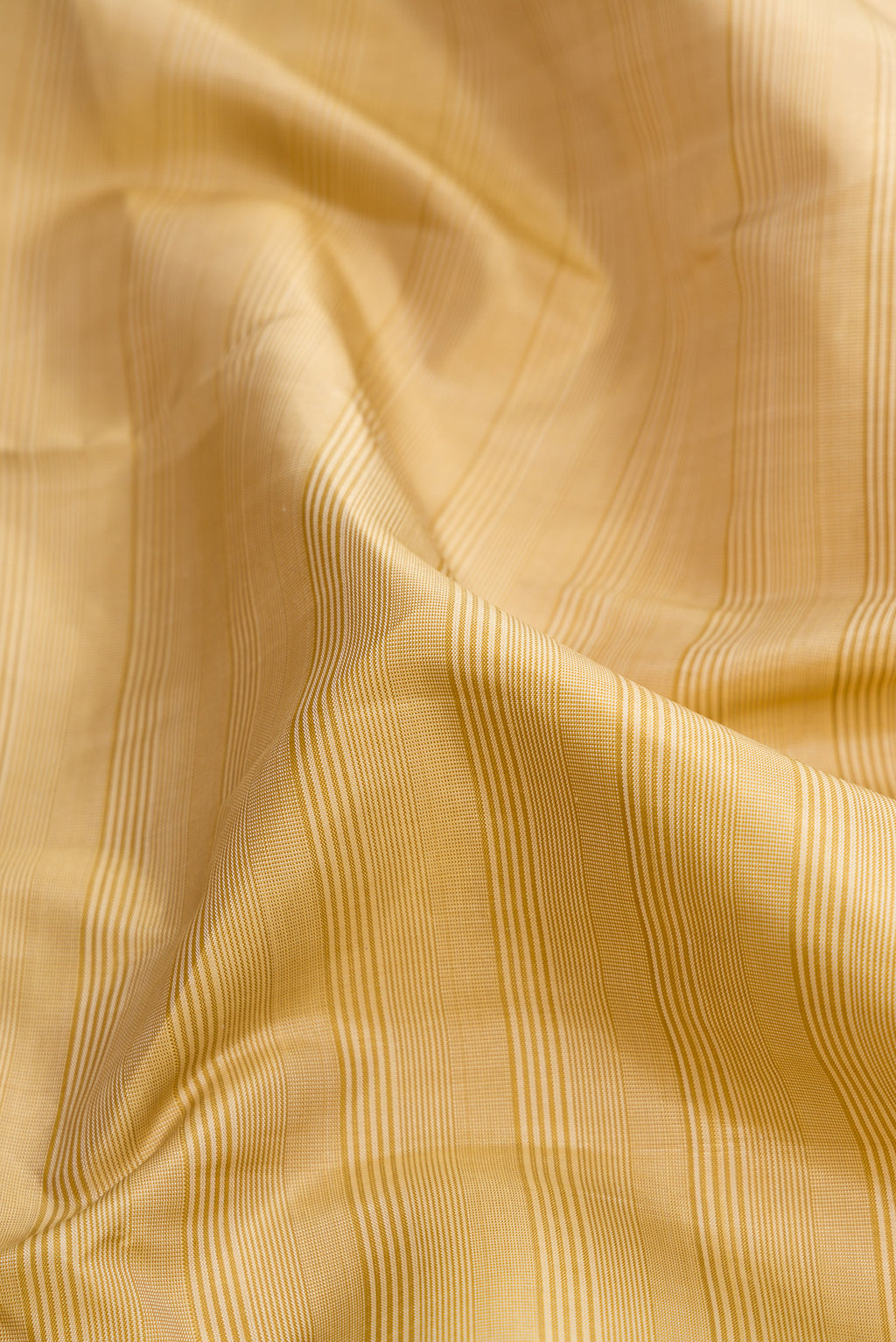 Close up of Beige Dual Tone Kanjivaram Silk Saree with Plain Body and Zari Border.  displaying folds