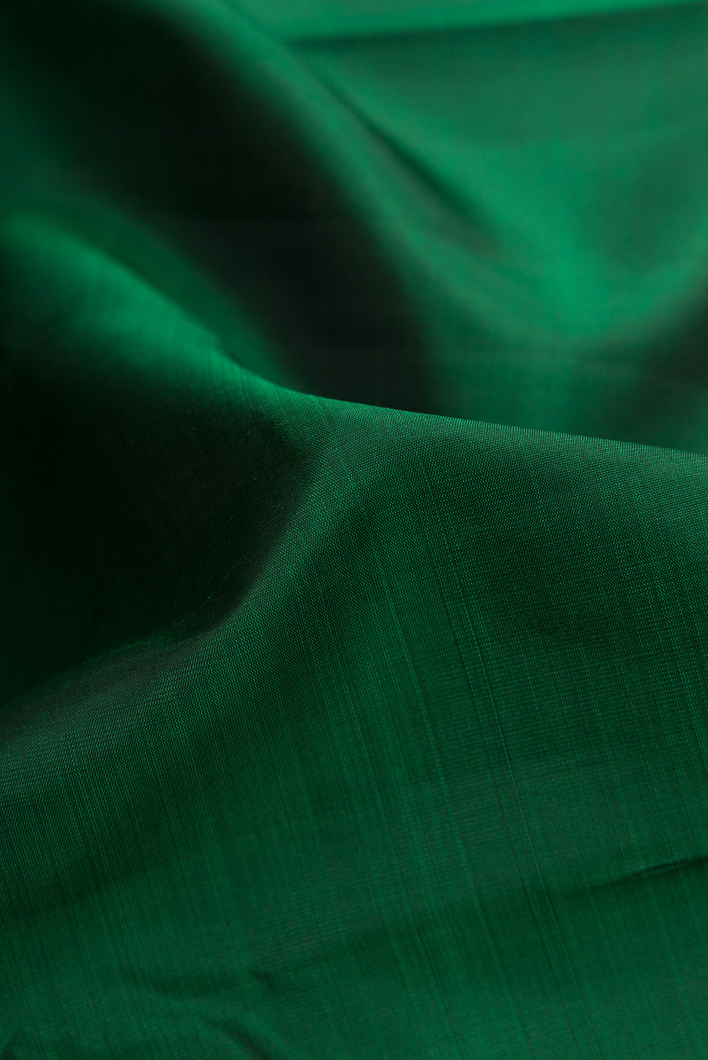 Close up of Bottle Green Dual Tone Kanjivaram Silk Saree with Plain Body and Zari Border.  displaying folds