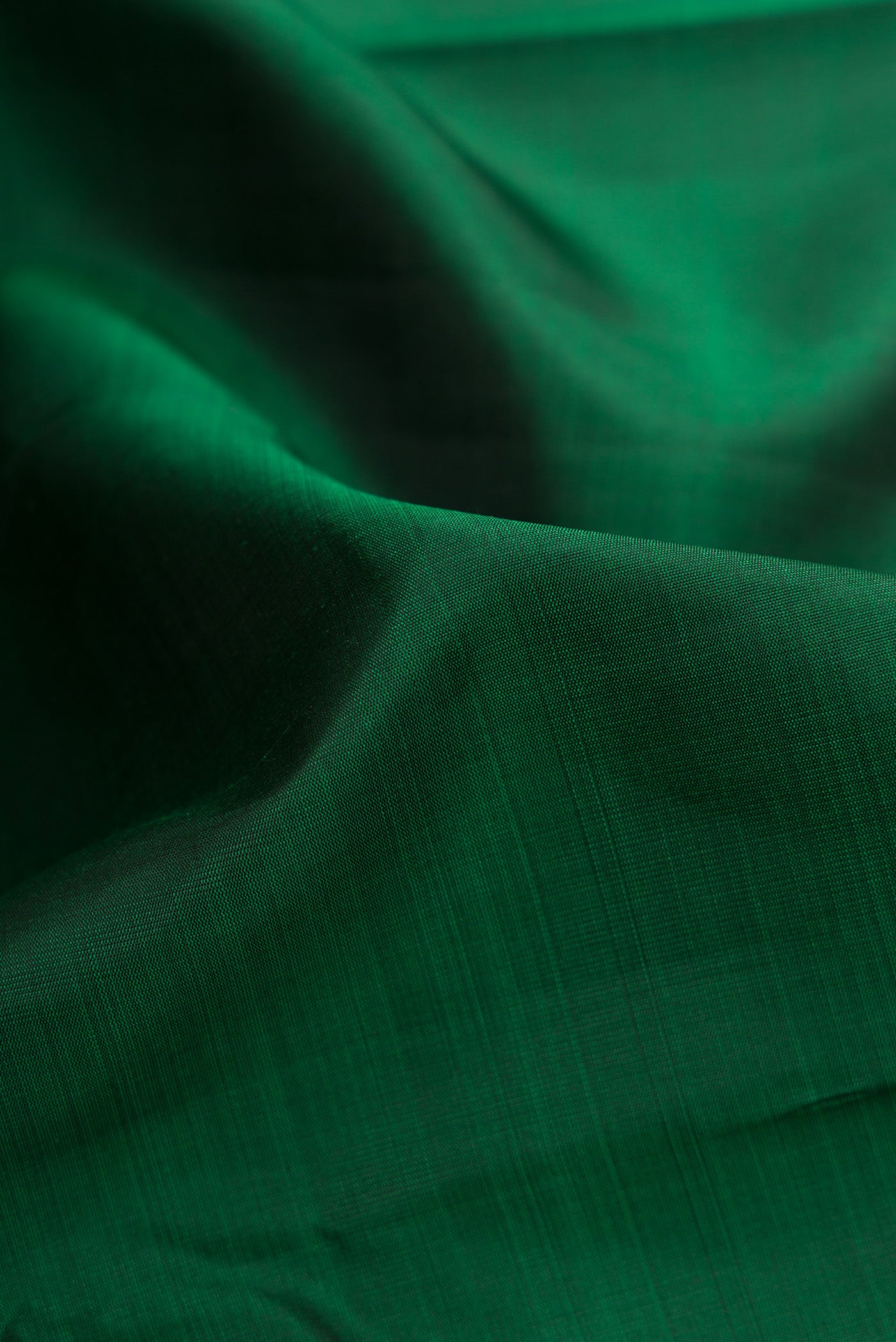 Close up of Bottle Green Dual Tone Kanjivaram Silk Saree with Plain Body and Zari Border.  displaying folds