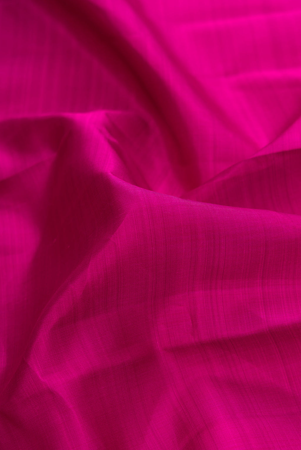 Close up of Magenta Dual Tone Kanjivaram Silk Saree with Plain Body and Zari Border.  displaying folds