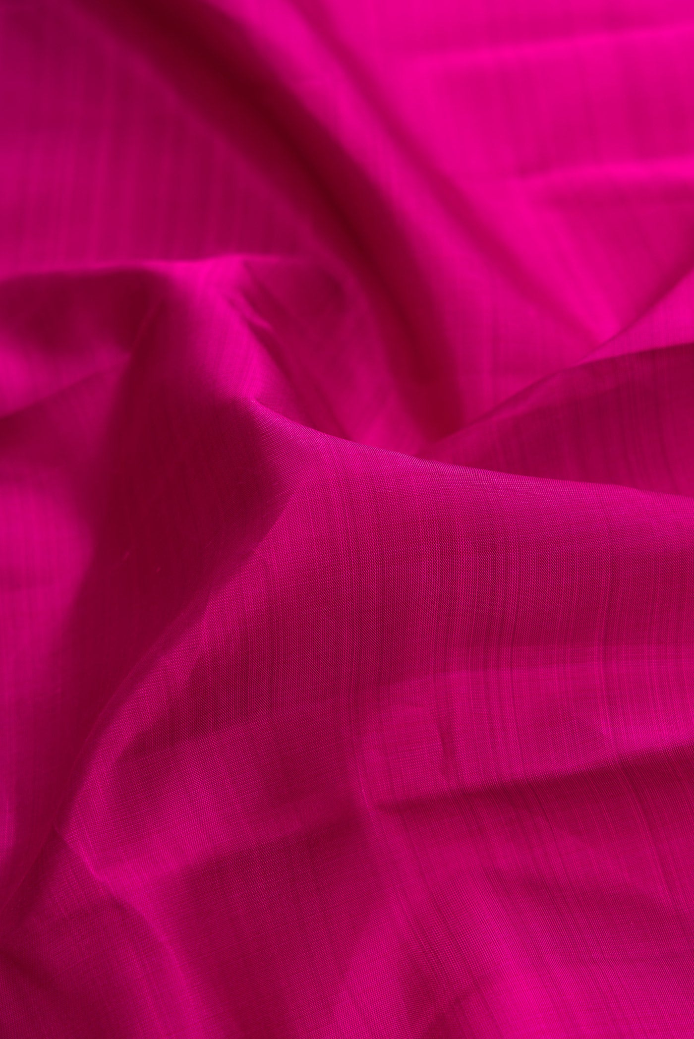 Close up of Magenta Dual Tone Kanjivaram Silk Saree with Plain Body and Zari Border.  displaying folds