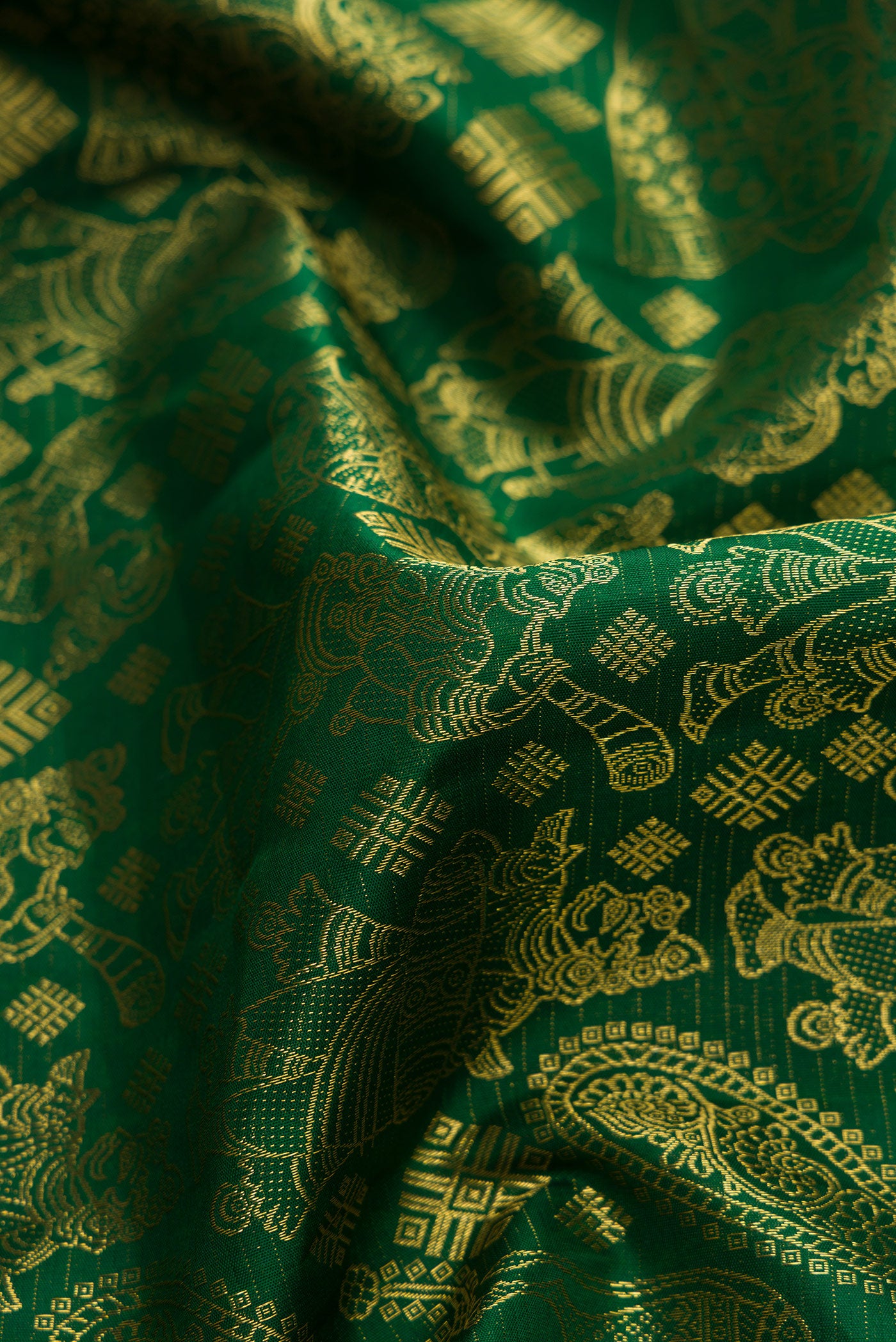 Close up of Green Dual Tone Kanchipuram Silk Saree with Zari Butta on the body and Zari Border.  displaying folds