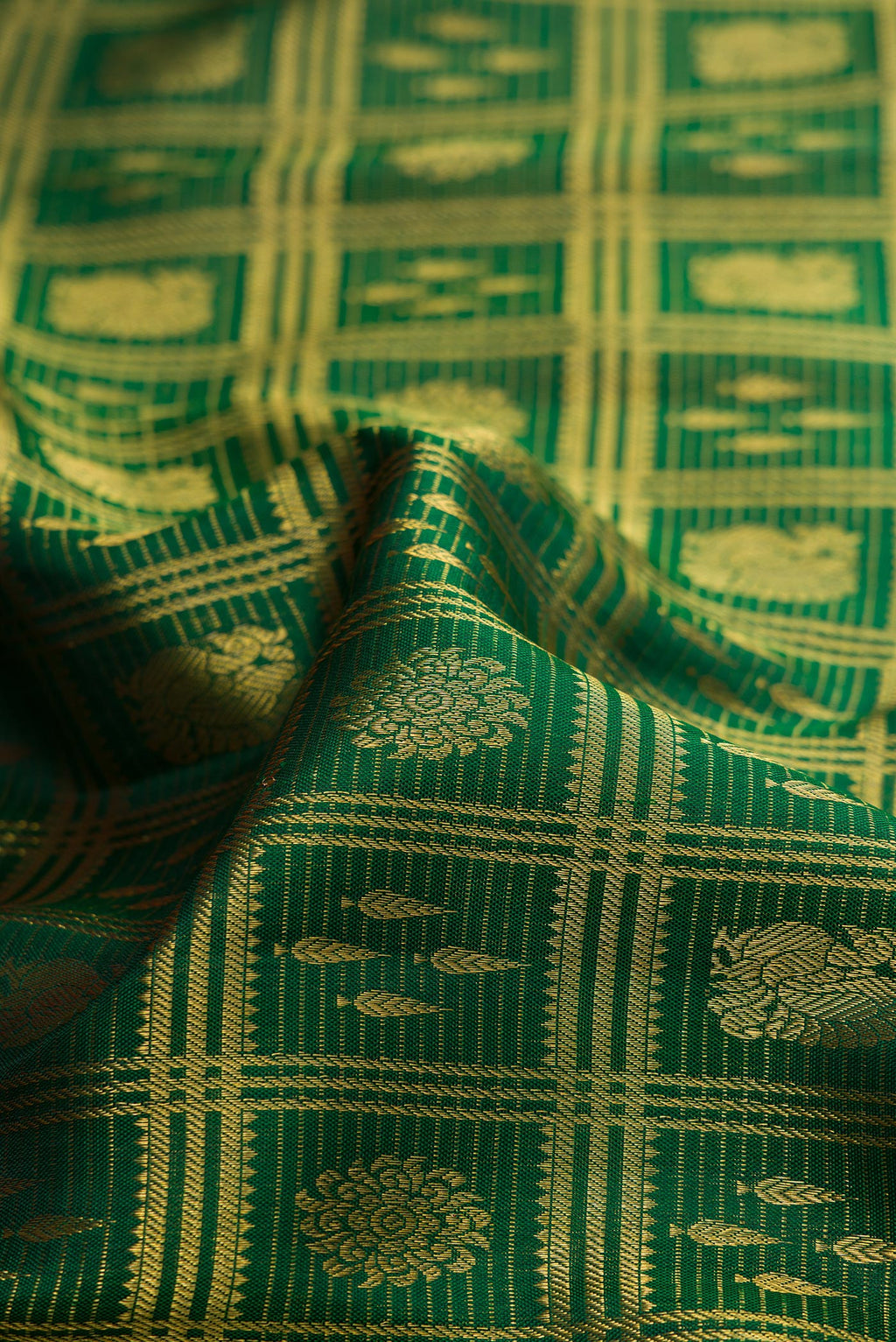 Close up of Bottle Green Kanchipuram Silk Saree with Zari Brocade on the body and Zari Border.  displaying folds