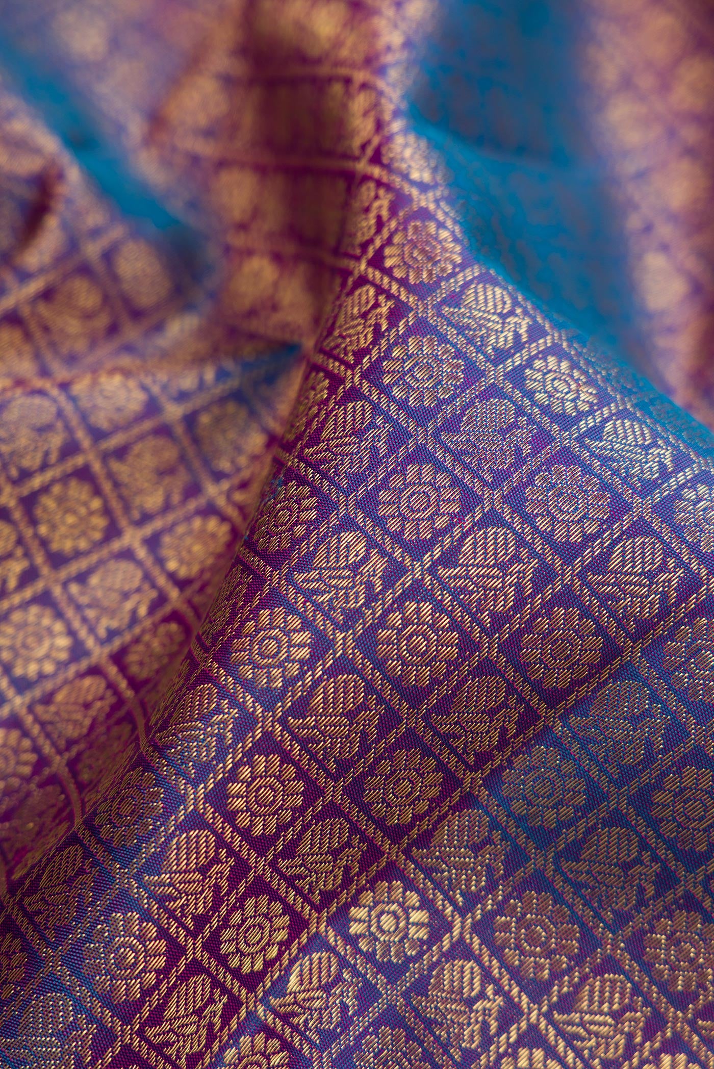 Close up of Pure Silk Pure Zari Peacock Blue Dual Tone Kanjivaram Saree with Zari Brocade on the body and Zari Border.  displaying folds