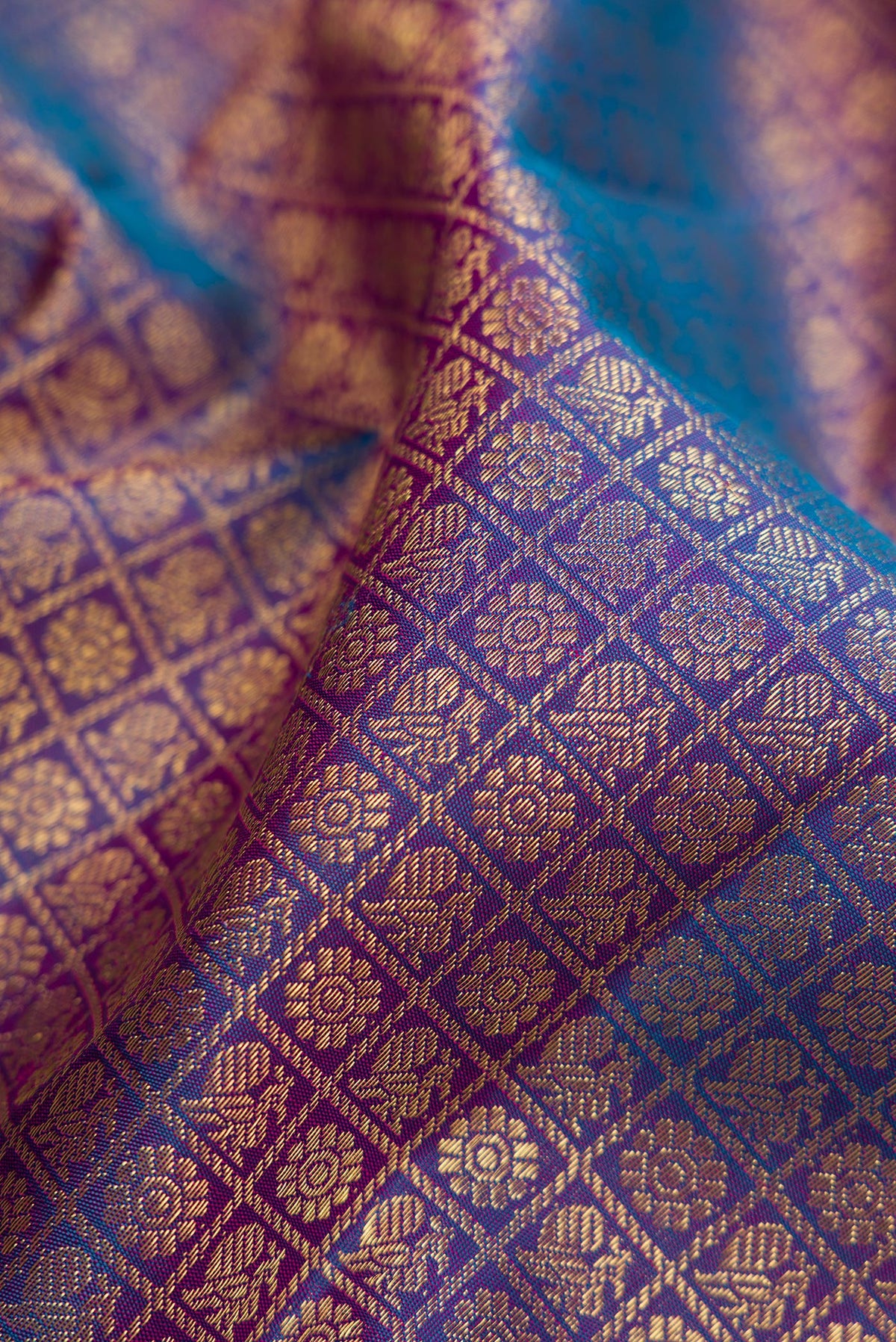 Close up of Pure Silk Pure Zari Peacock Blue Dual Tone Kanjivaram Saree with Zari Brocade on the body and Zari Border.  displaying folds