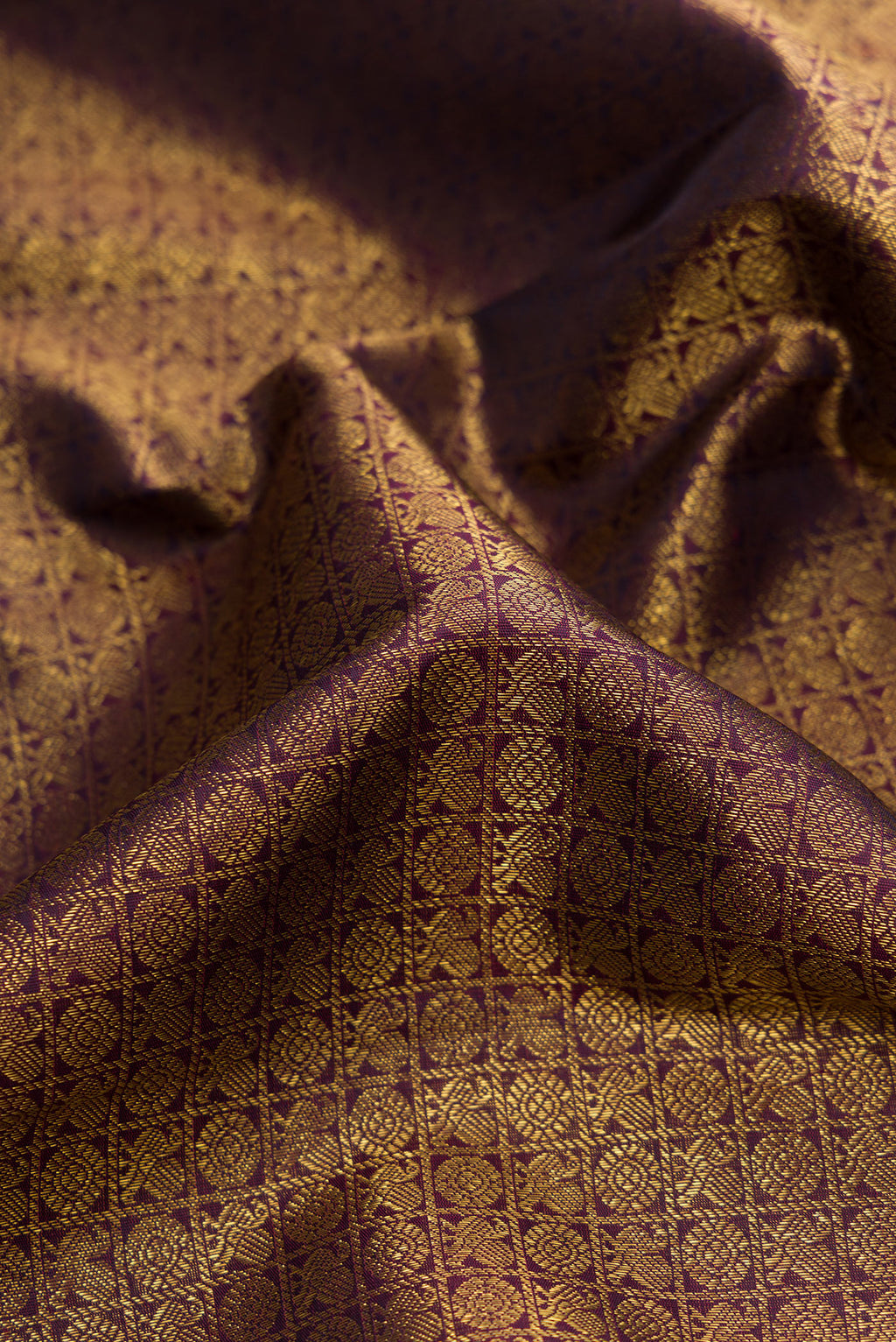 Close up of Pure Silk Pure Zari Burgundy Dual Tone Kanjivaram Saree with Zari Brocade on the body and Zari Border.  displaying folds