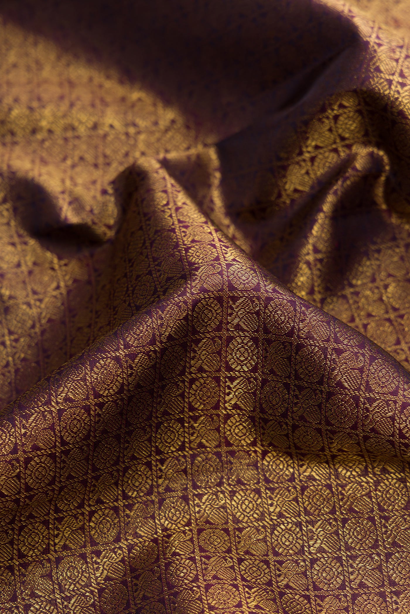 Close up of Pure Silk Pure Zari Burgundy Dual Tone Kanjivaram Saree with Zari Brocade on the body and Zari Border.  displaying folds