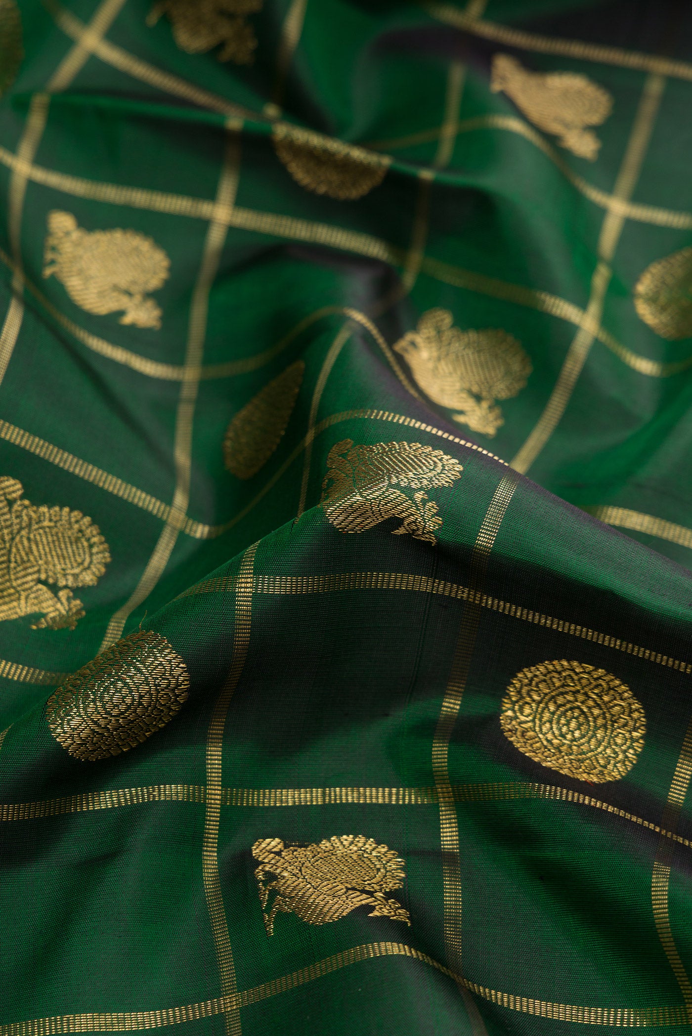 Close up of Pure Silk Pure Zari Bottle Green Dual Tone Kanjivaram Saree with Checked design on the body and Zari And Thread Border.  displaying folds