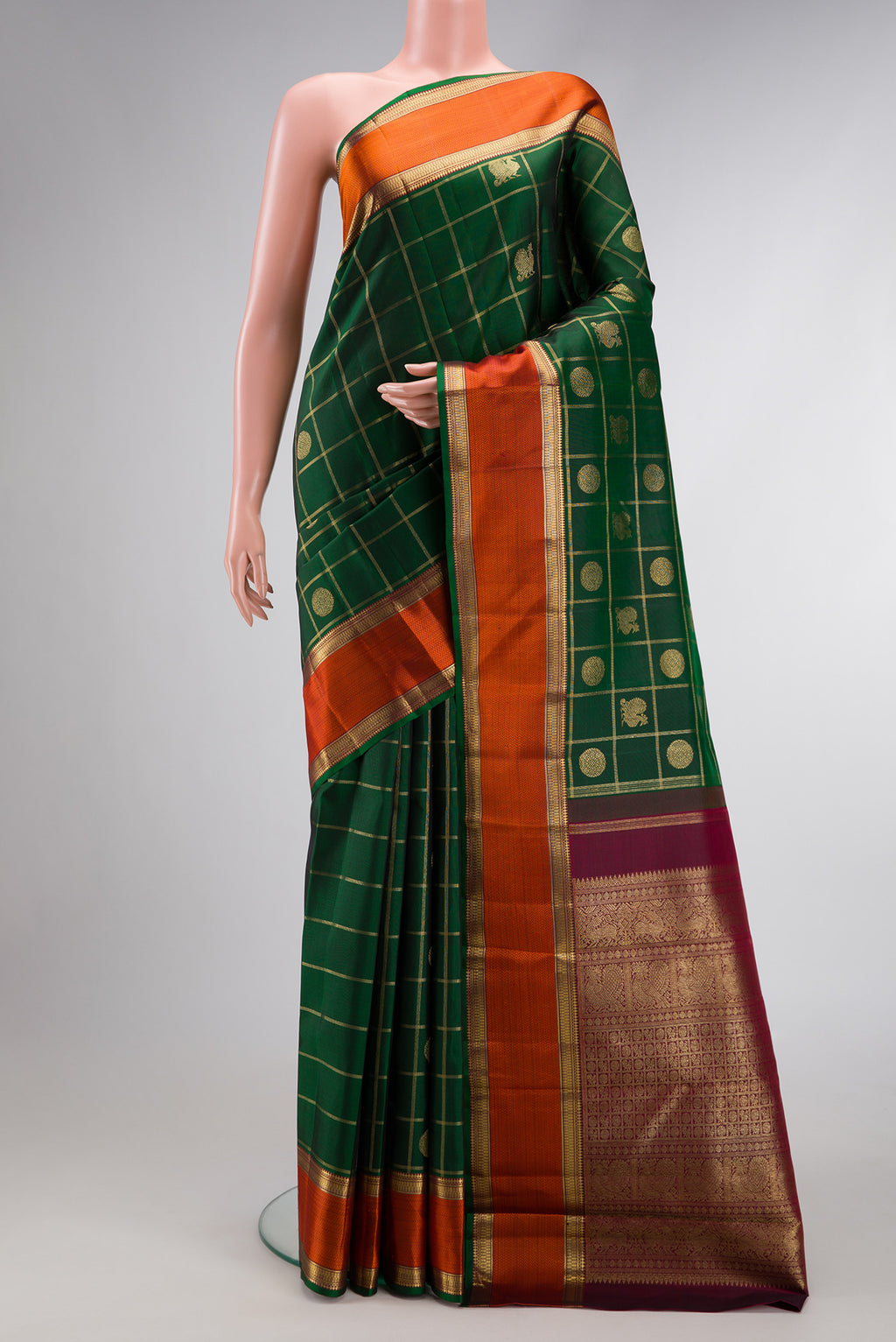 Pure Silk Pure Zari Bottle Green Dual Tone Kanjivaram Saree with Checked design on the body and Zari And Thread Border.  displayed on a mannequin