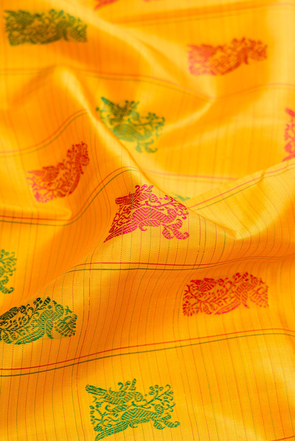 Close up of Mustard Dual Tone Kanchipuram Silk Saree with Stripes on the body and Fancy Border.  displaying folds