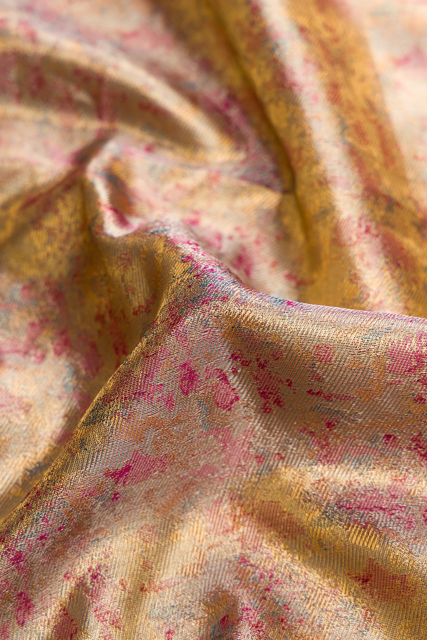 Close up of Gold Dual Tone Kanjivaram Tissue Silk Saree with Zari Brocade on the body and Fancy Border.  displaying folds