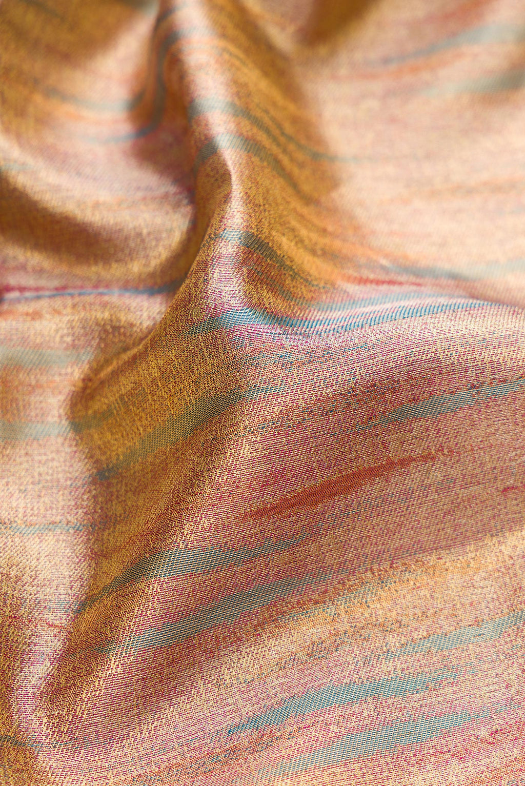 Close up of Rose Gold Dual Tone Kanjivaram Tissue Silk Saree with Zari Brocade on the body and Zari Border.  displaying folds