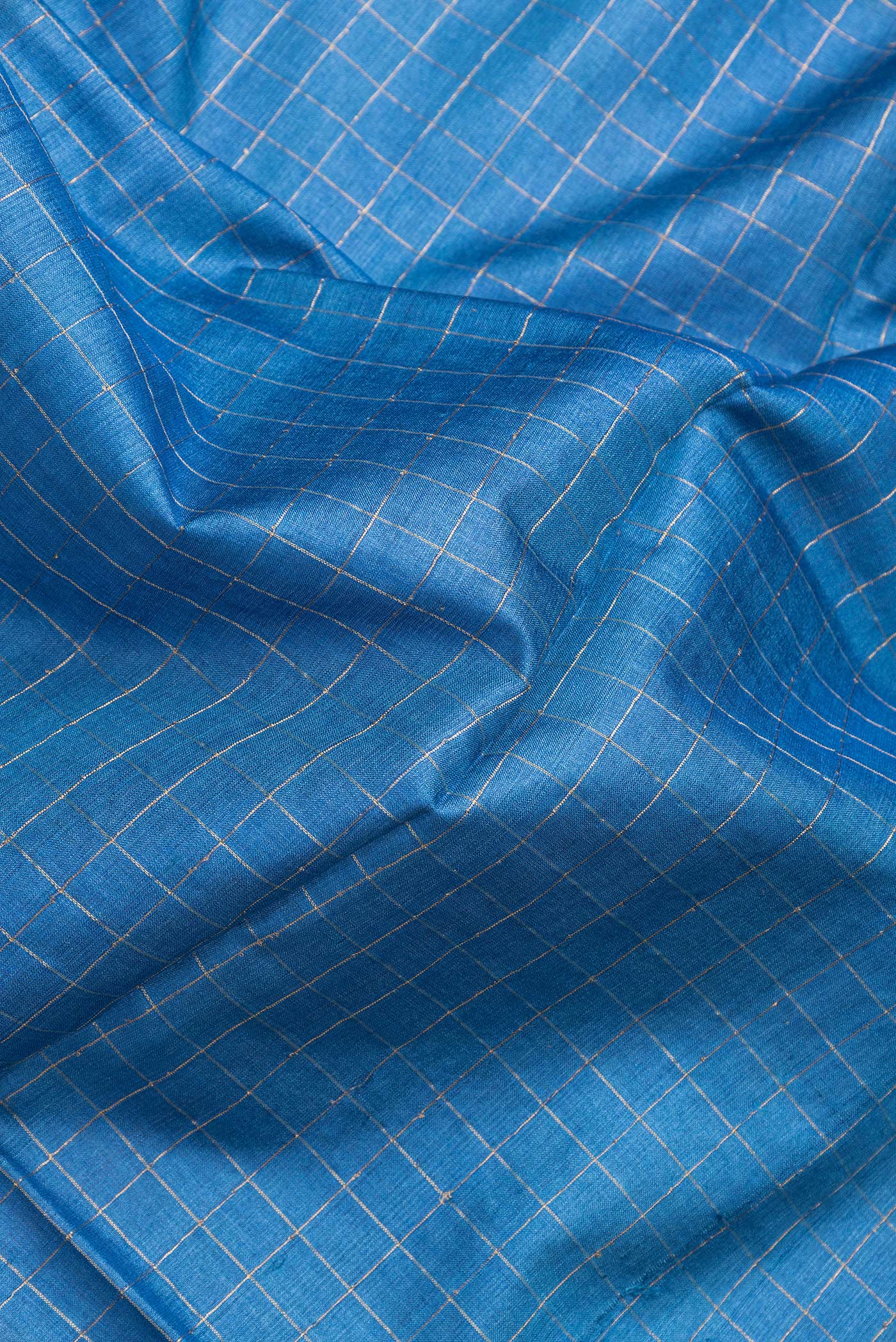 Close up of Royal Blue Dual Tone Tussar Silk Saree with Checked design on the body and Printed Border.  displaying folds