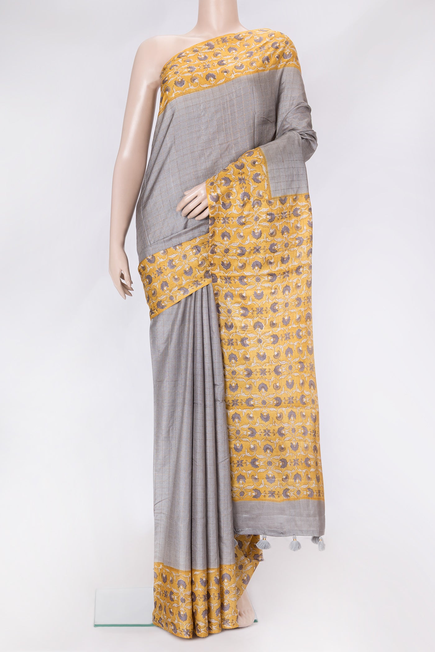 Grey Dual Tone Tussar Silk Saree with Checked design on the body and Printed Border.  displayed on a mannequin