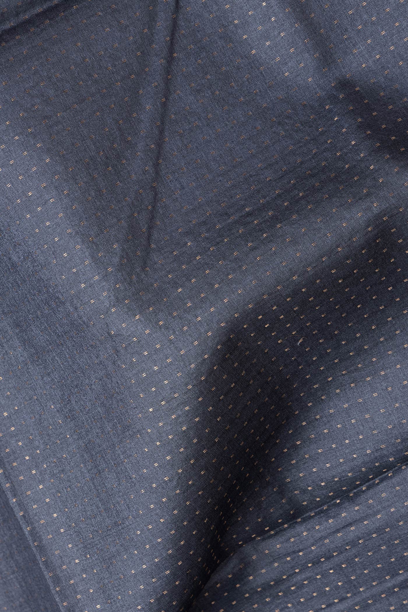Close up of Black Dual Tone Tussar Silk Saree with Zari Butta on the body and Printed Border.  displaying folds