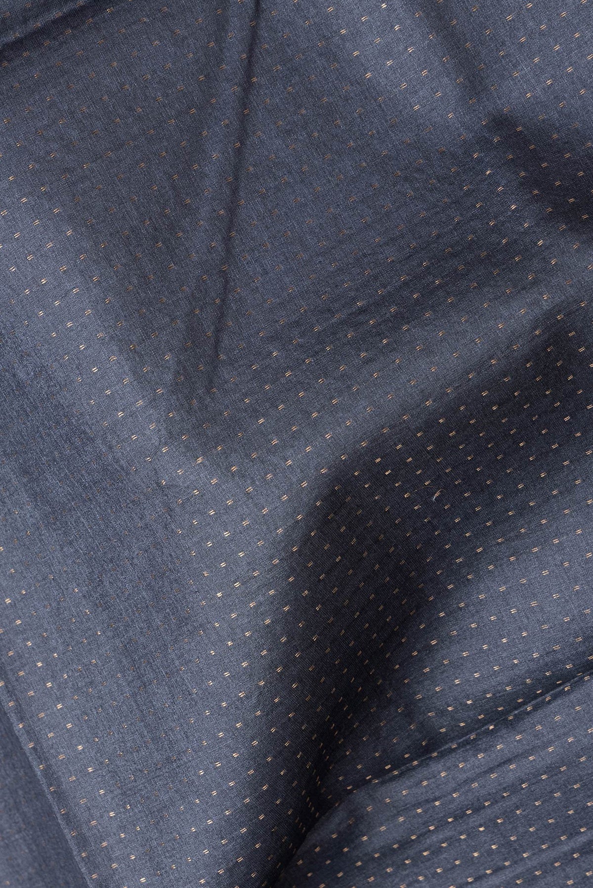 Close up of Black Dual Tone Tussar Silk Saree with Zari Butta on the body and Printed Border.  displaying folds