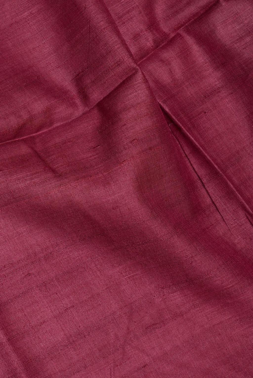 Close up of Maroon Tussar Silk Saree with Plain Body and Fancy Border.  displaying folds