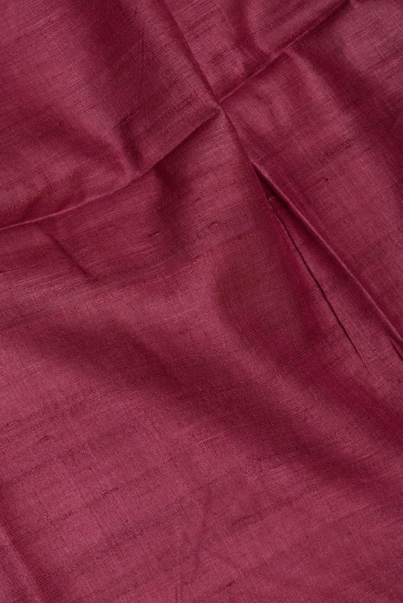 Close up of Maroon Tussar Silk Saree with Plain Body and Fancy Border.  displaying folds