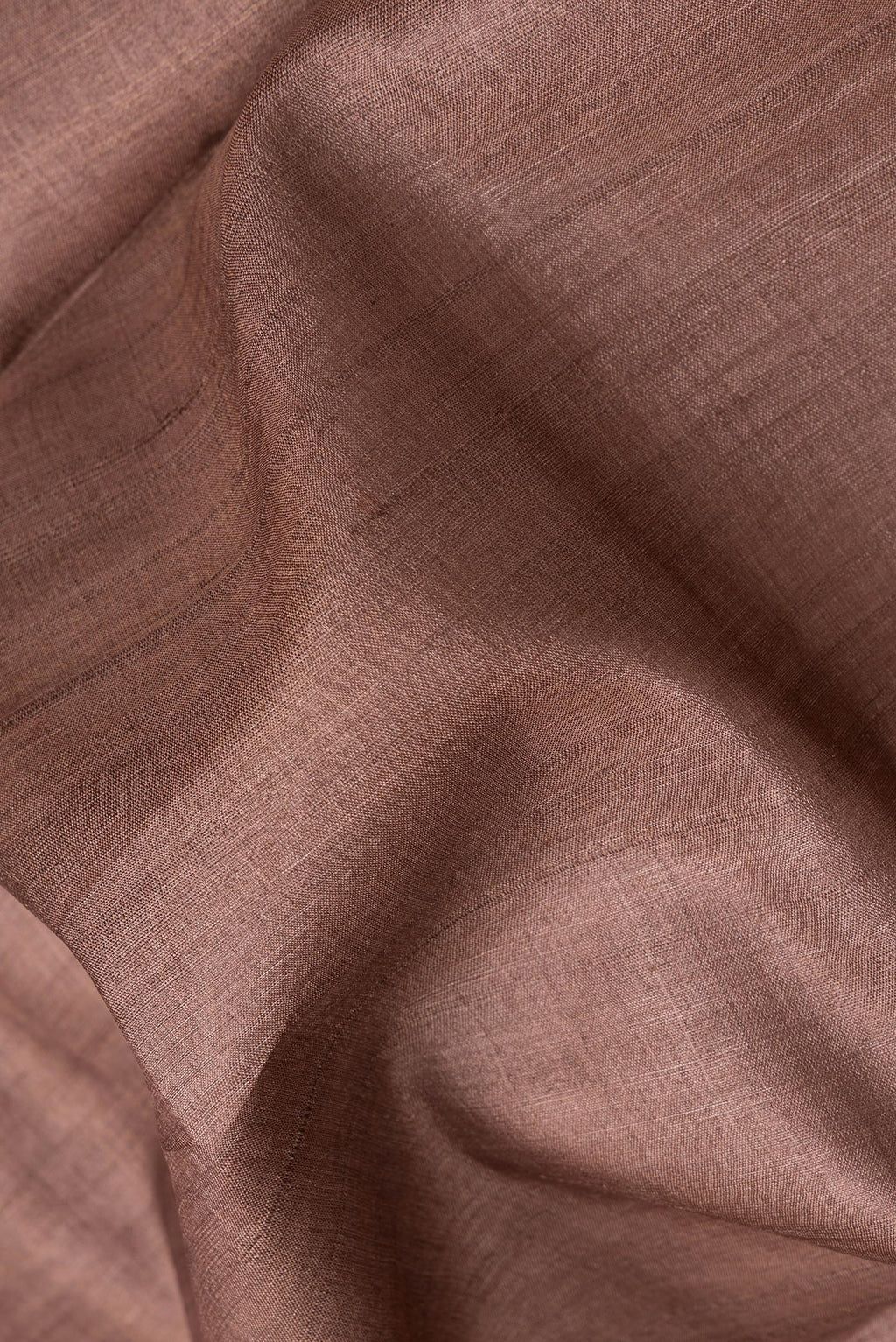 Close up of Brown Tussar Silk Saree with Plain Body and Fancy Border.  displaying folds