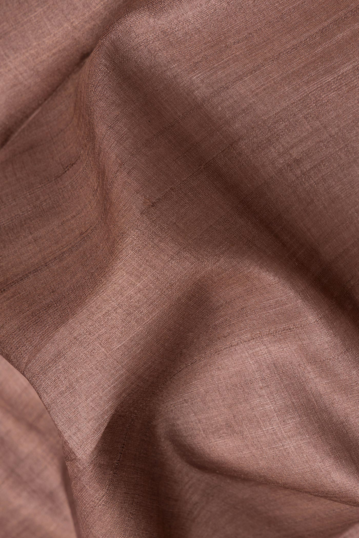 Close up of Brown Tussar Silk Saree with Plain Body and Fancy Border.  displaying folds