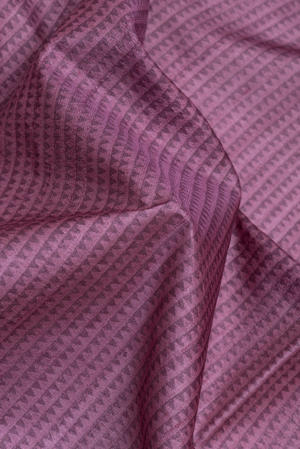 Close up of Purple Tussar Silk Saree with Printed design on the body and Fancy Border.  displaying folds
