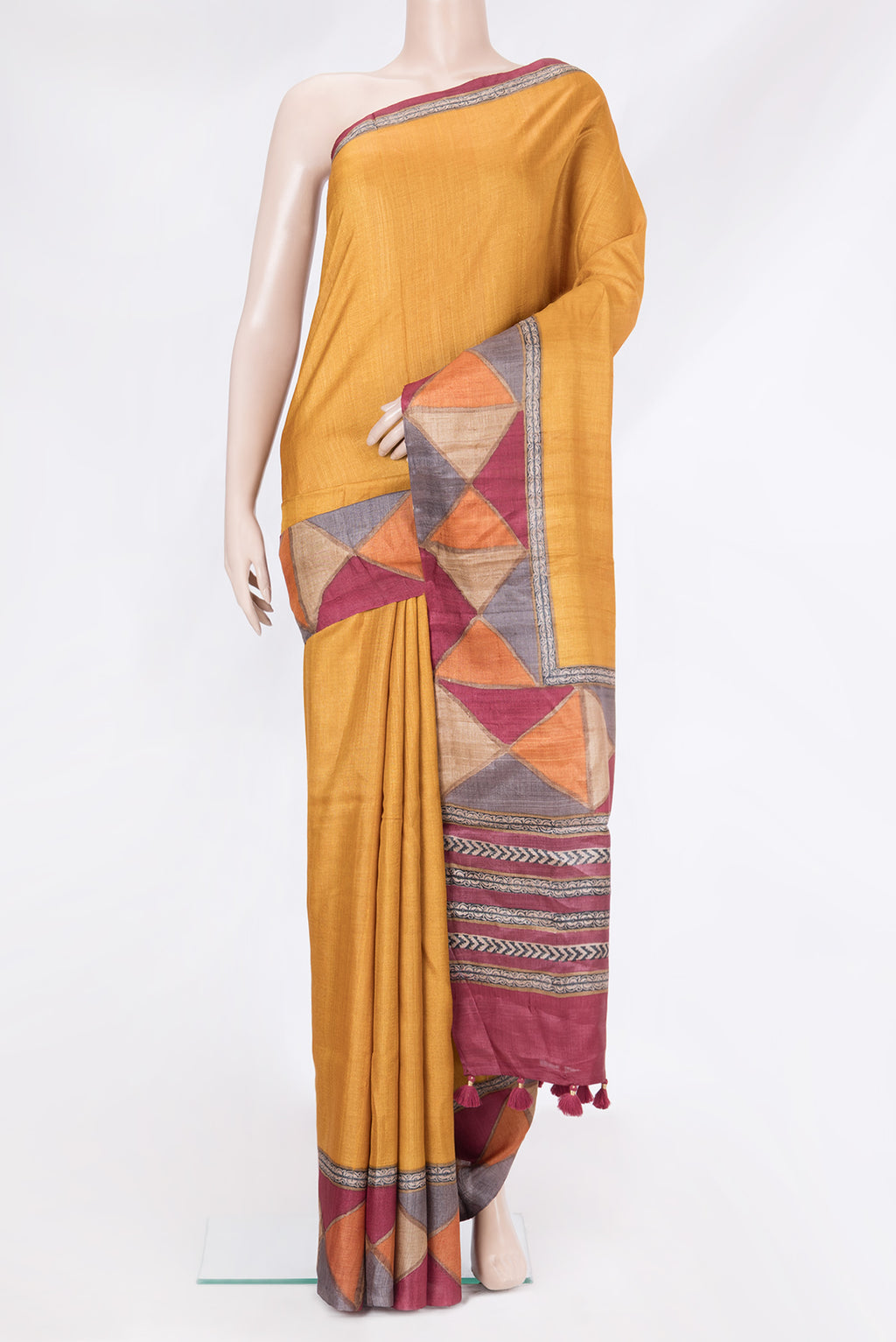 Mustard Tussar Silk Saree with Plain Body and Fancy Border.  displayed on a mannequin
