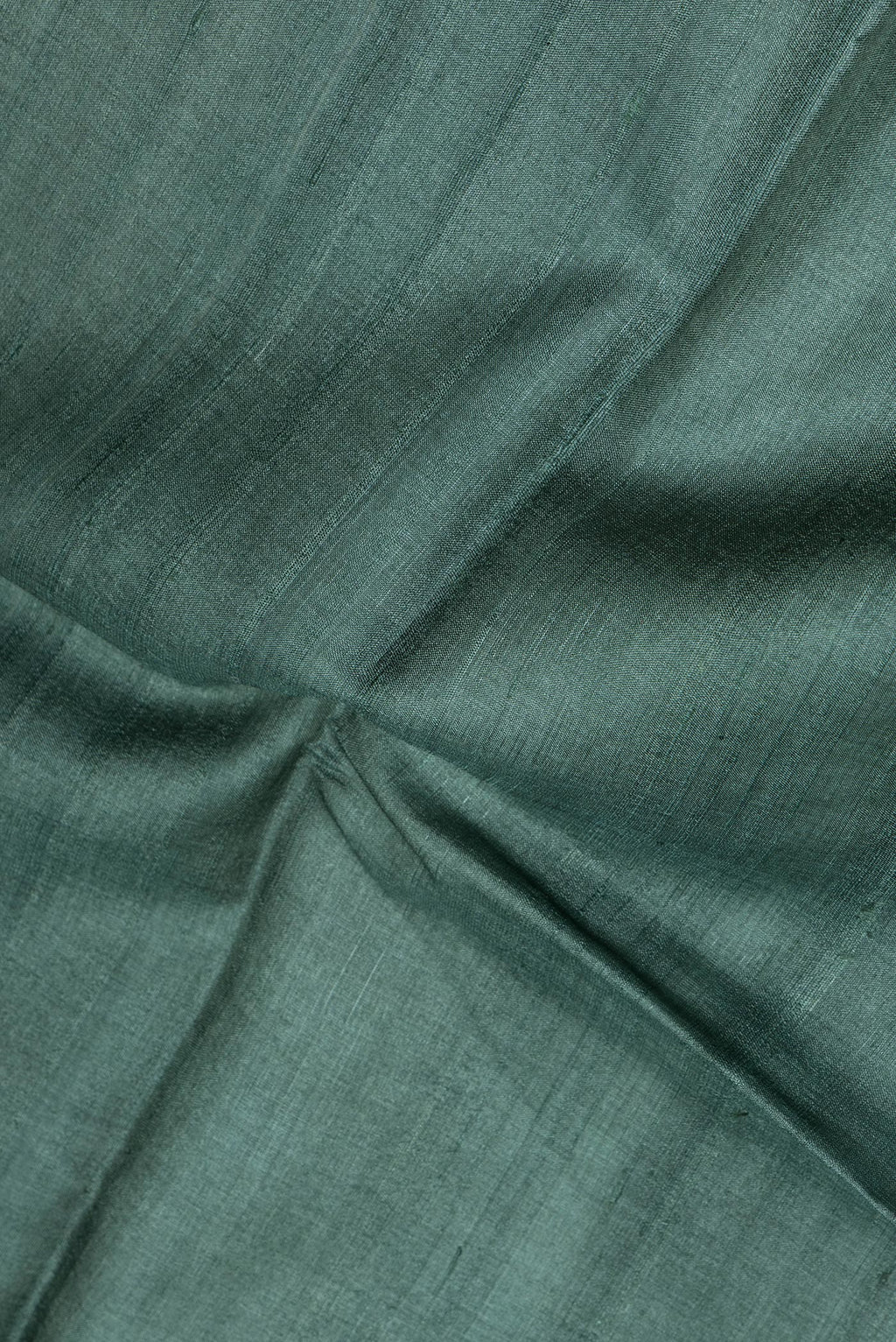 Close up of Green Tussar Silk Saree with Plain Body and Fancy Border.  displaying folds