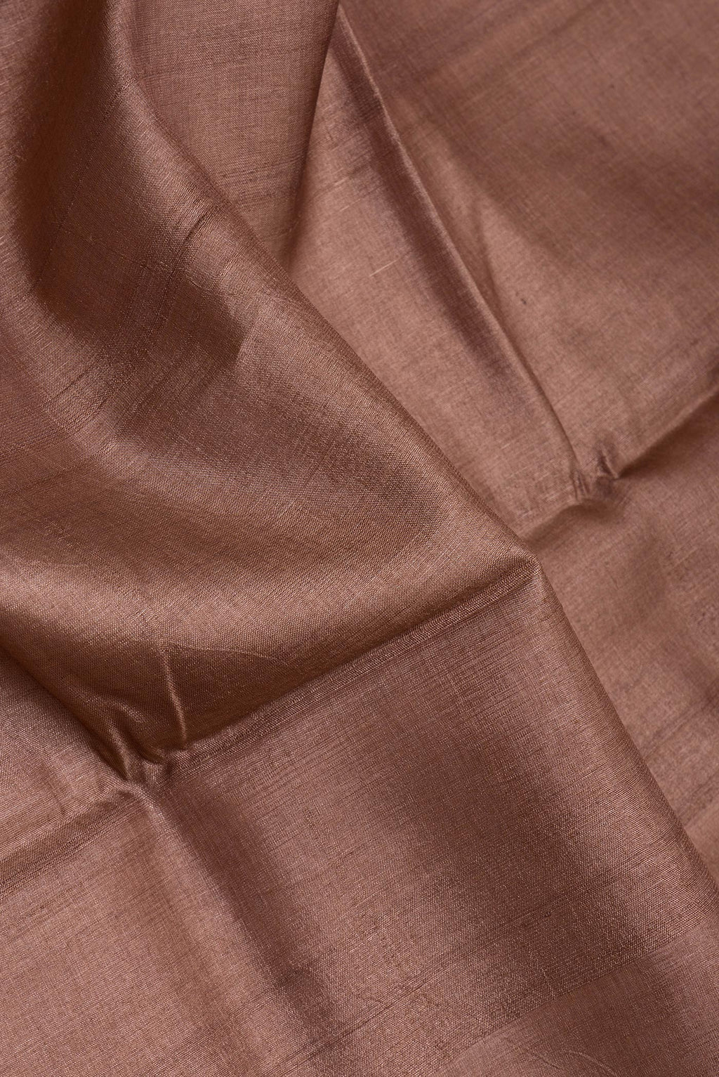 Close up of Brown Tussar Silk Saree with Plain Body and Printed Border.  displaying folds