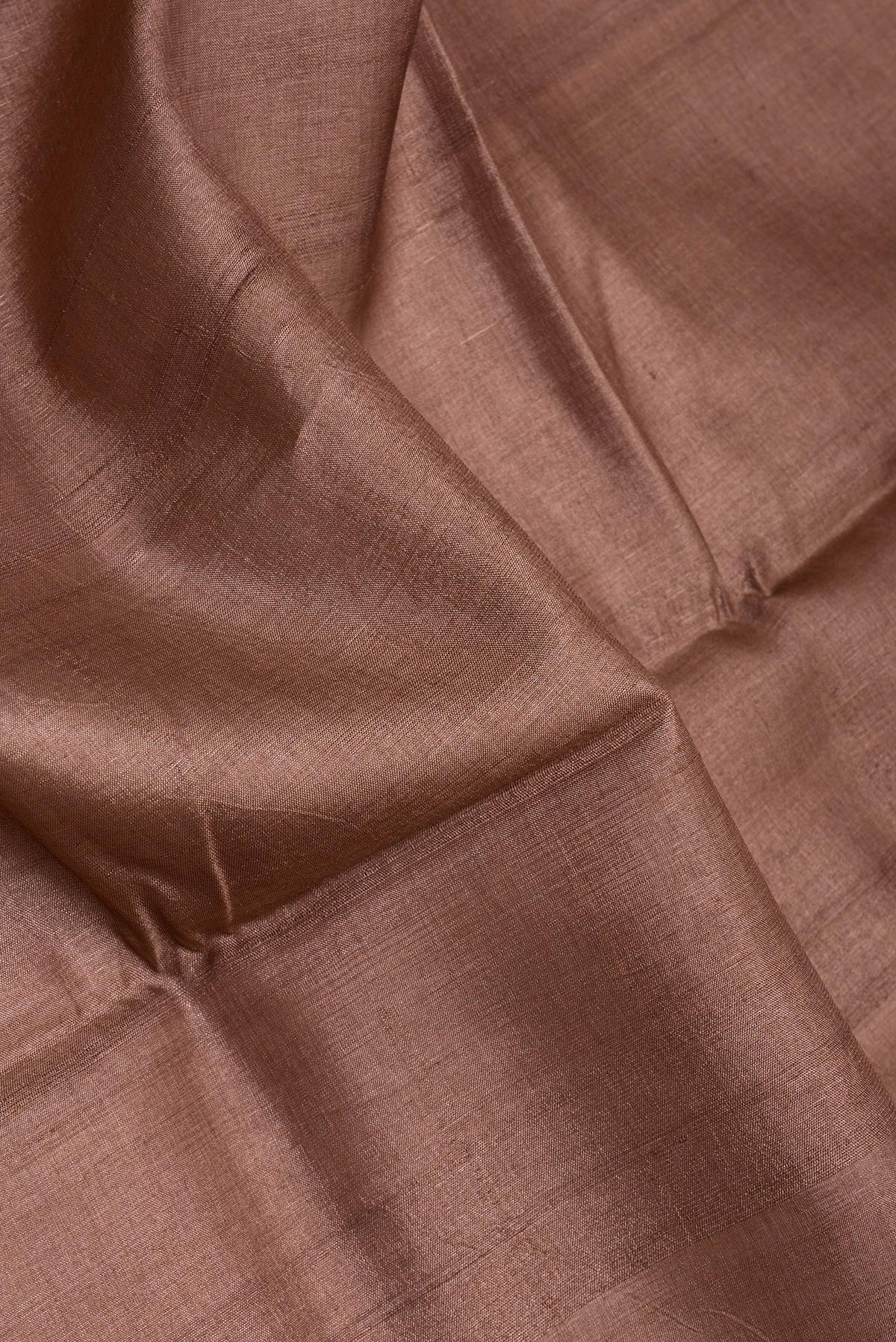 Close up of Brown Tussar Silk Saree with Plain Body and Printed Border.  displaying folds