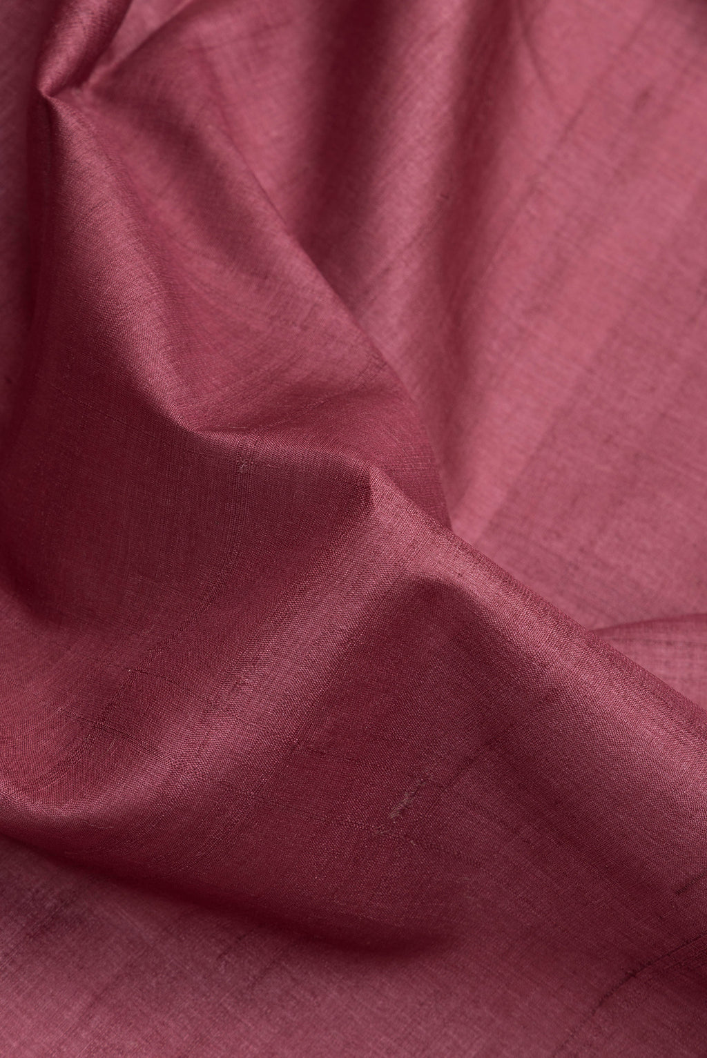 Close up of Maroon Dual Tone Tussar Silk Saree with Plain Body and Fancy Border.  displaying folds